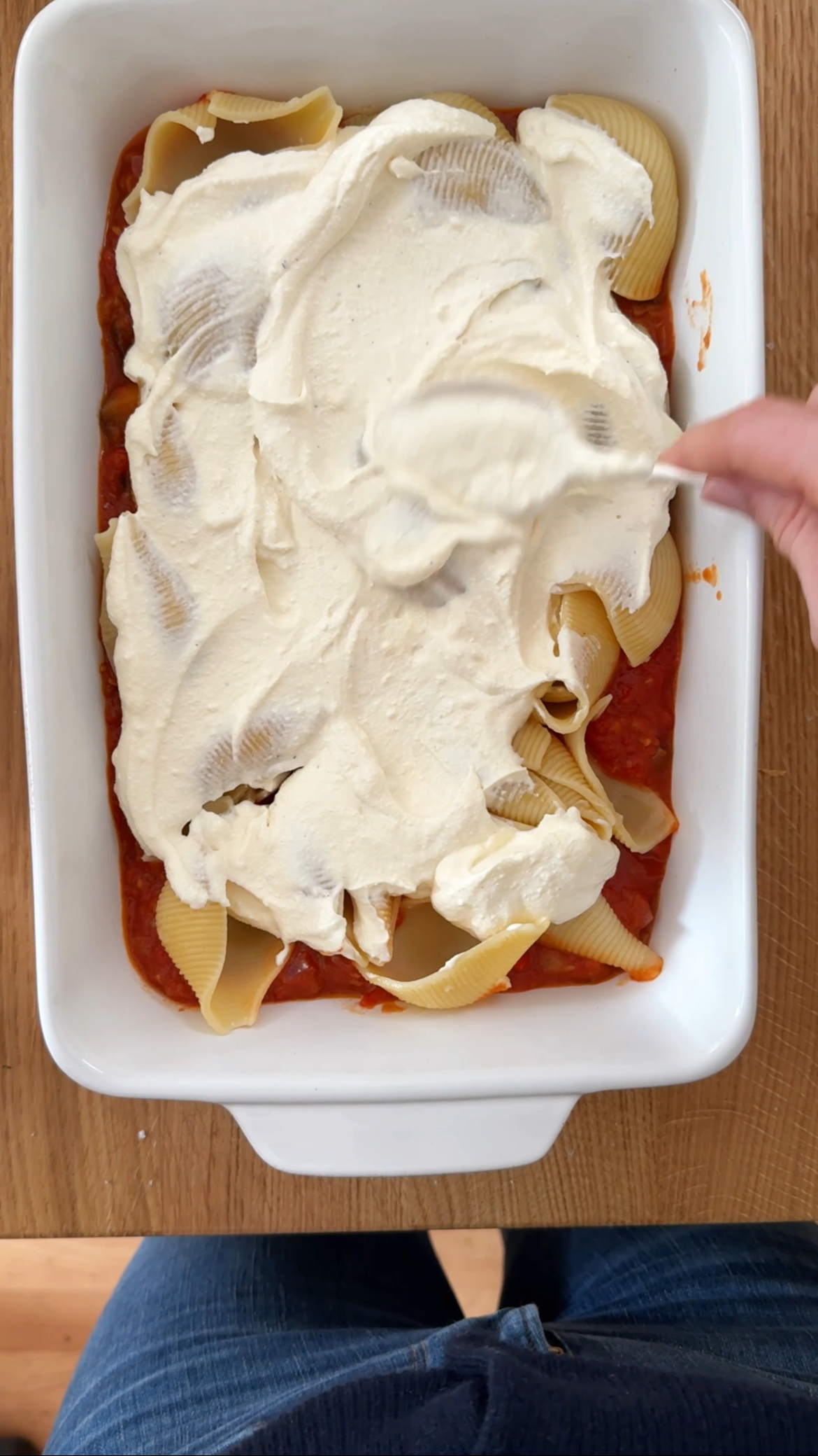 spreading creamy sauce onto the shells