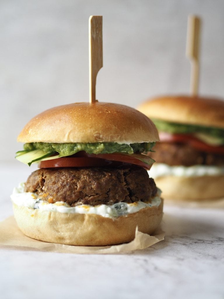 Lamb burgers pictured close up on a white countertop.