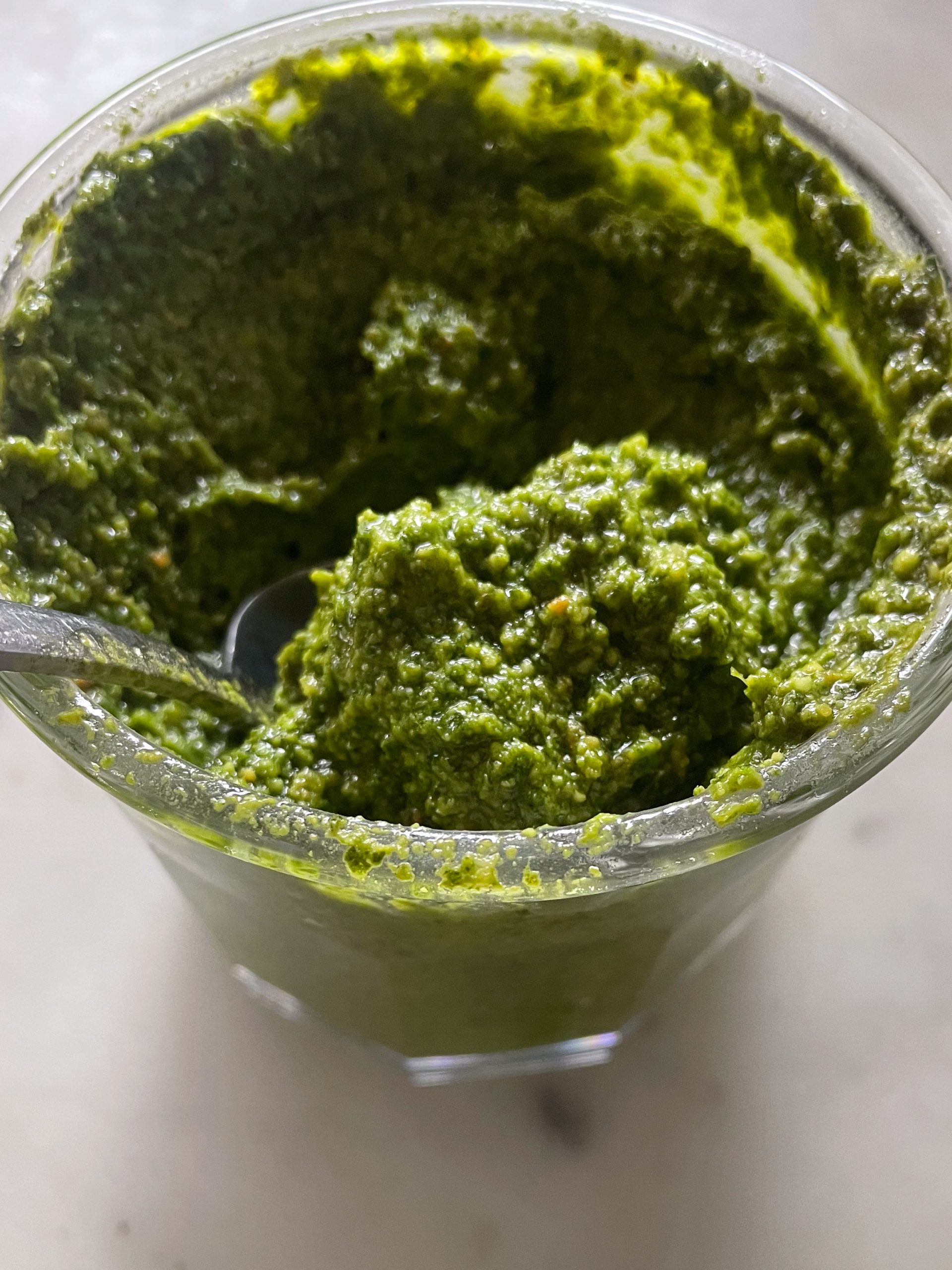 Close up of a jar of homemade basil pesto.