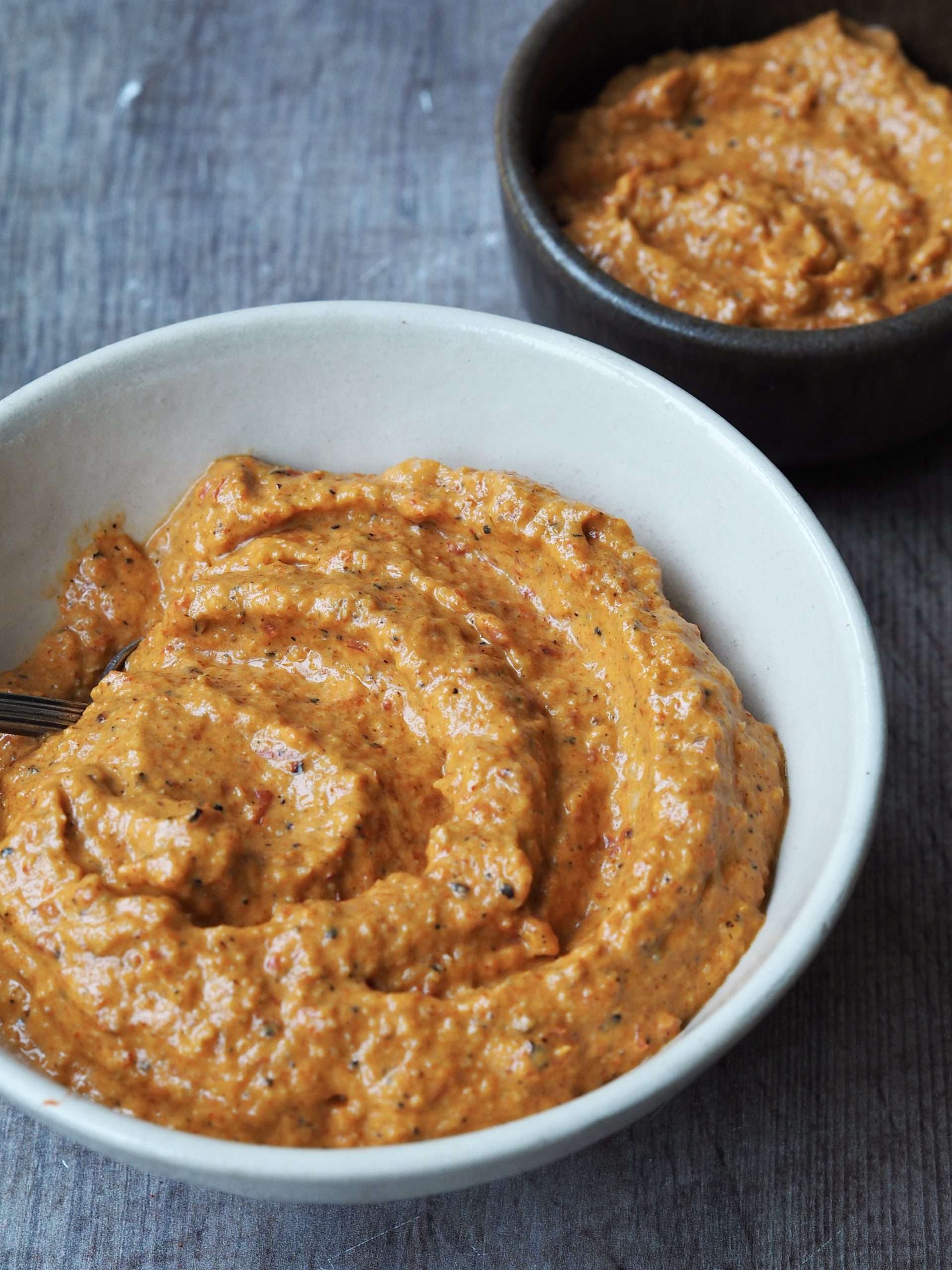 White bowl of creamy romesco sauce.