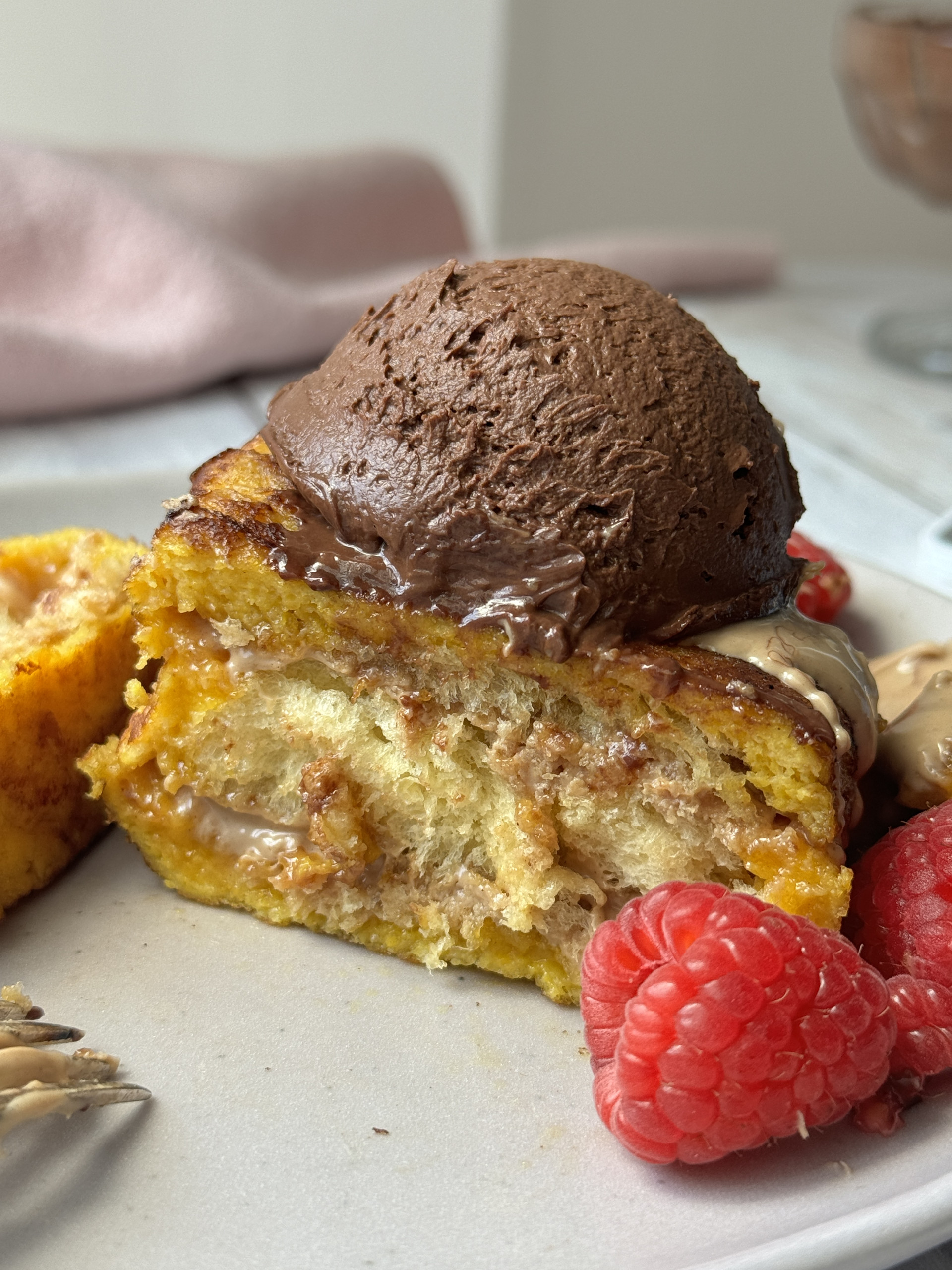 hong kong fnrech toast on a plate with raspberries and chocolate whipped cream