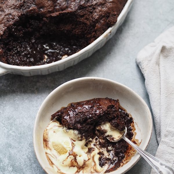 Self Saucing Chocolate Pudding scooped into a bowl with ice cream