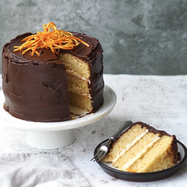 jaffa cake cake with a slice removed on a black plate