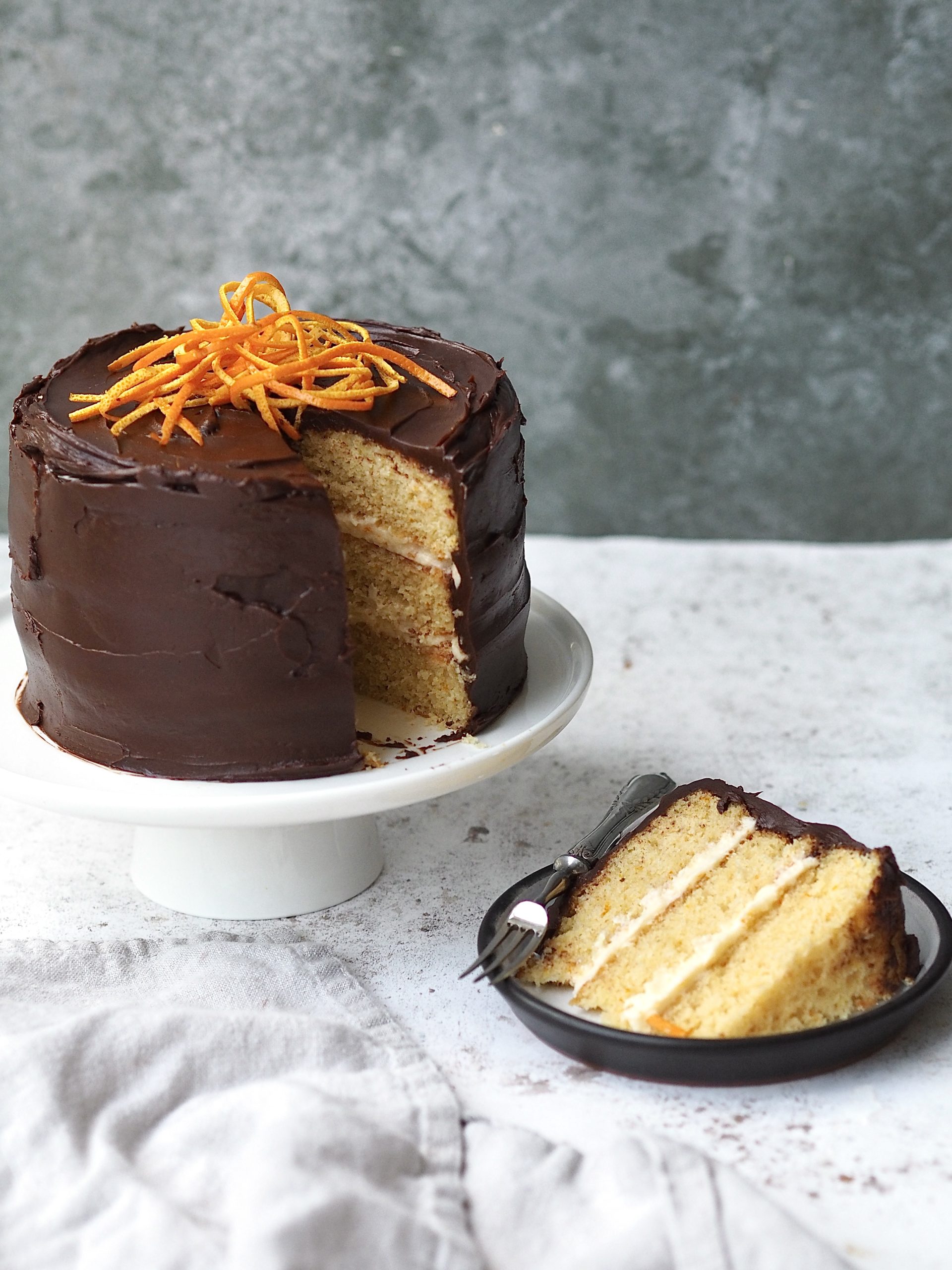 jaffa cake cake with a slice removed on a black plate