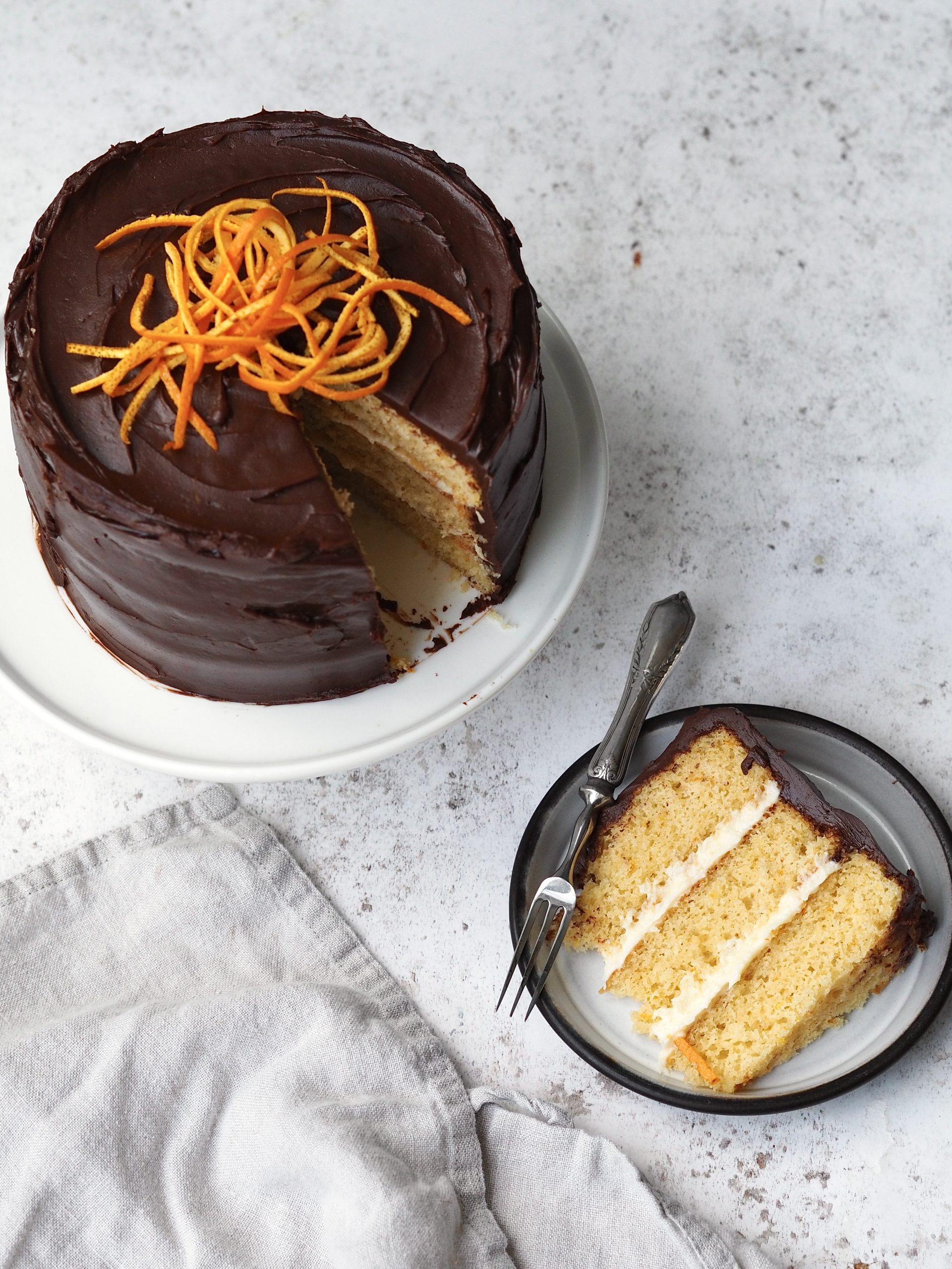 jaffa cake cake with a slice removed on a black plate