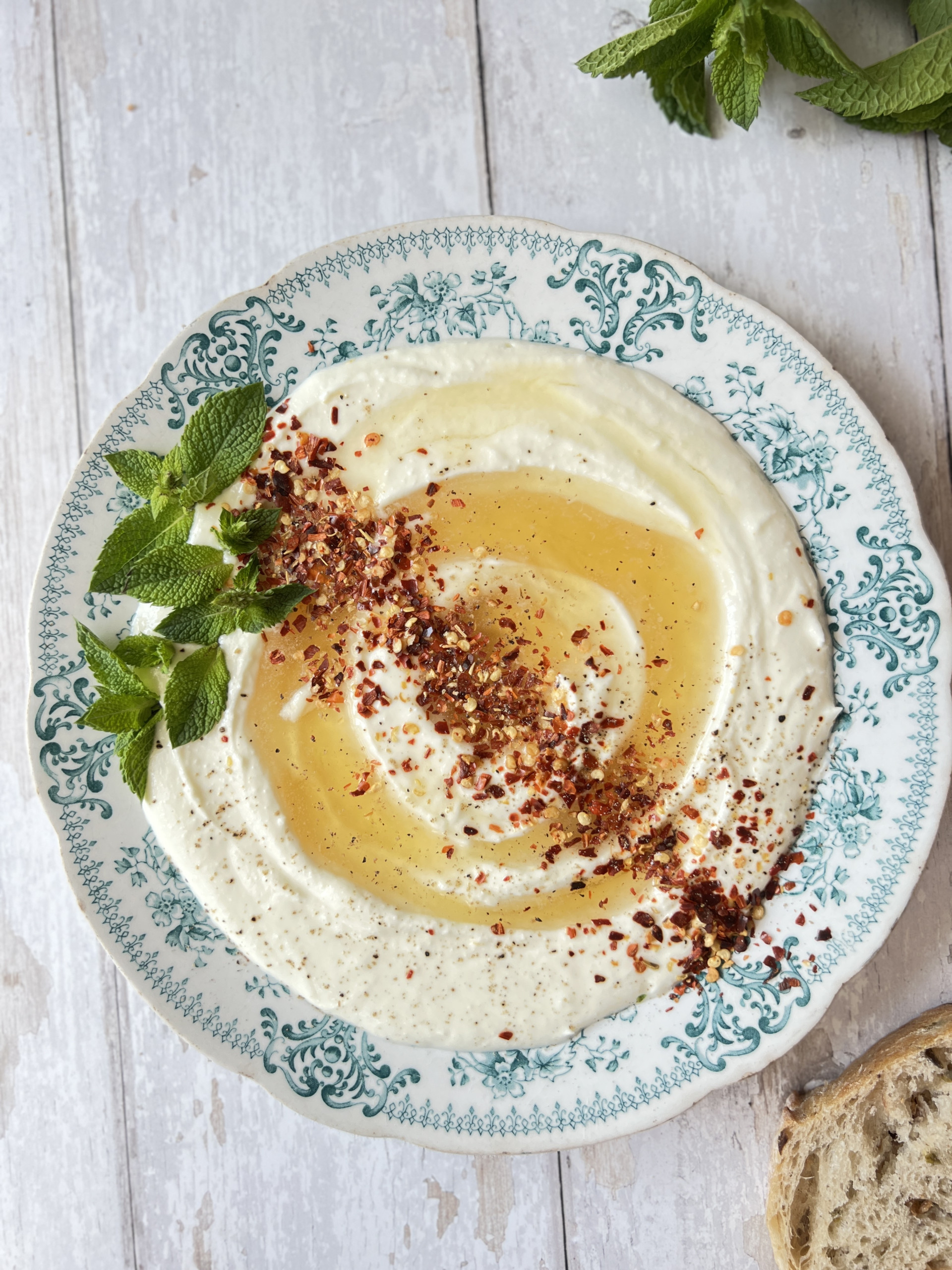 whipped ricotta cheese on a blue plate with honey and chilli flakes