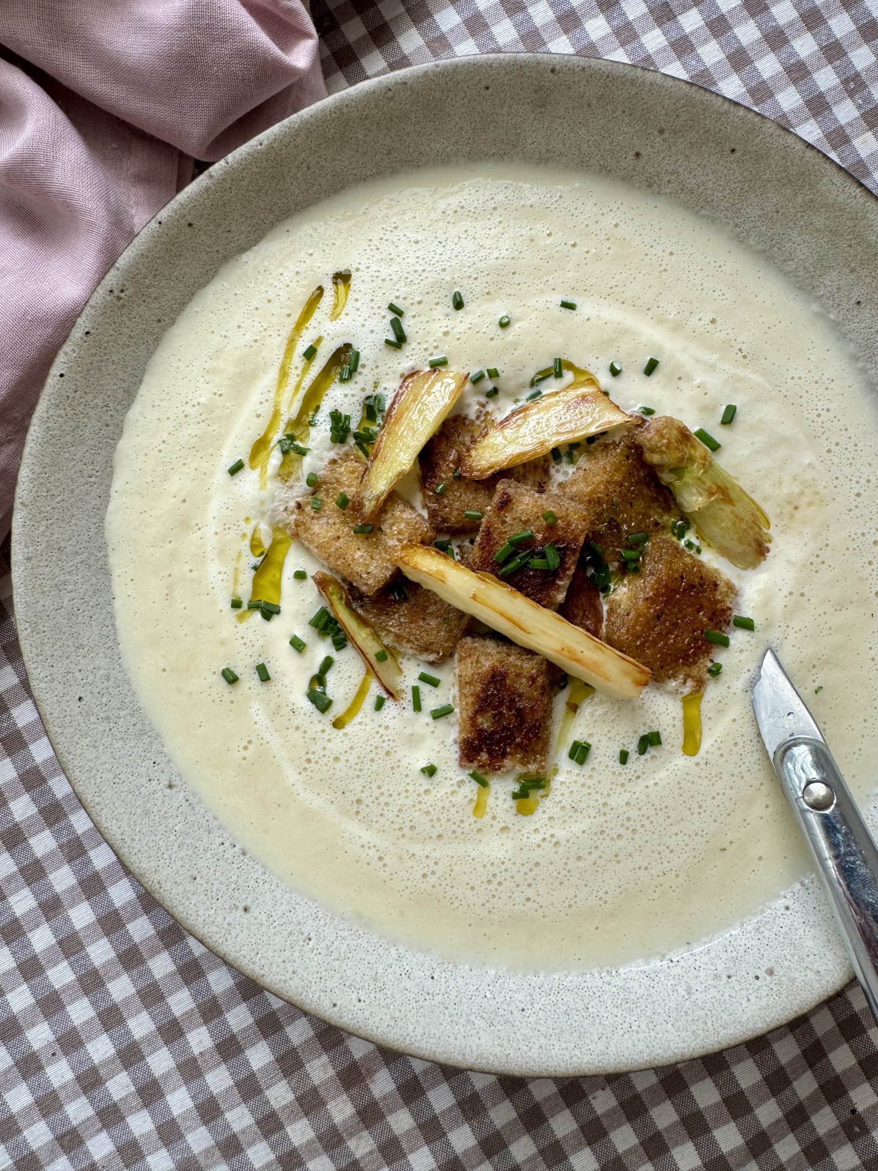 spargel, white asparagus soup in a white bowl with toppings