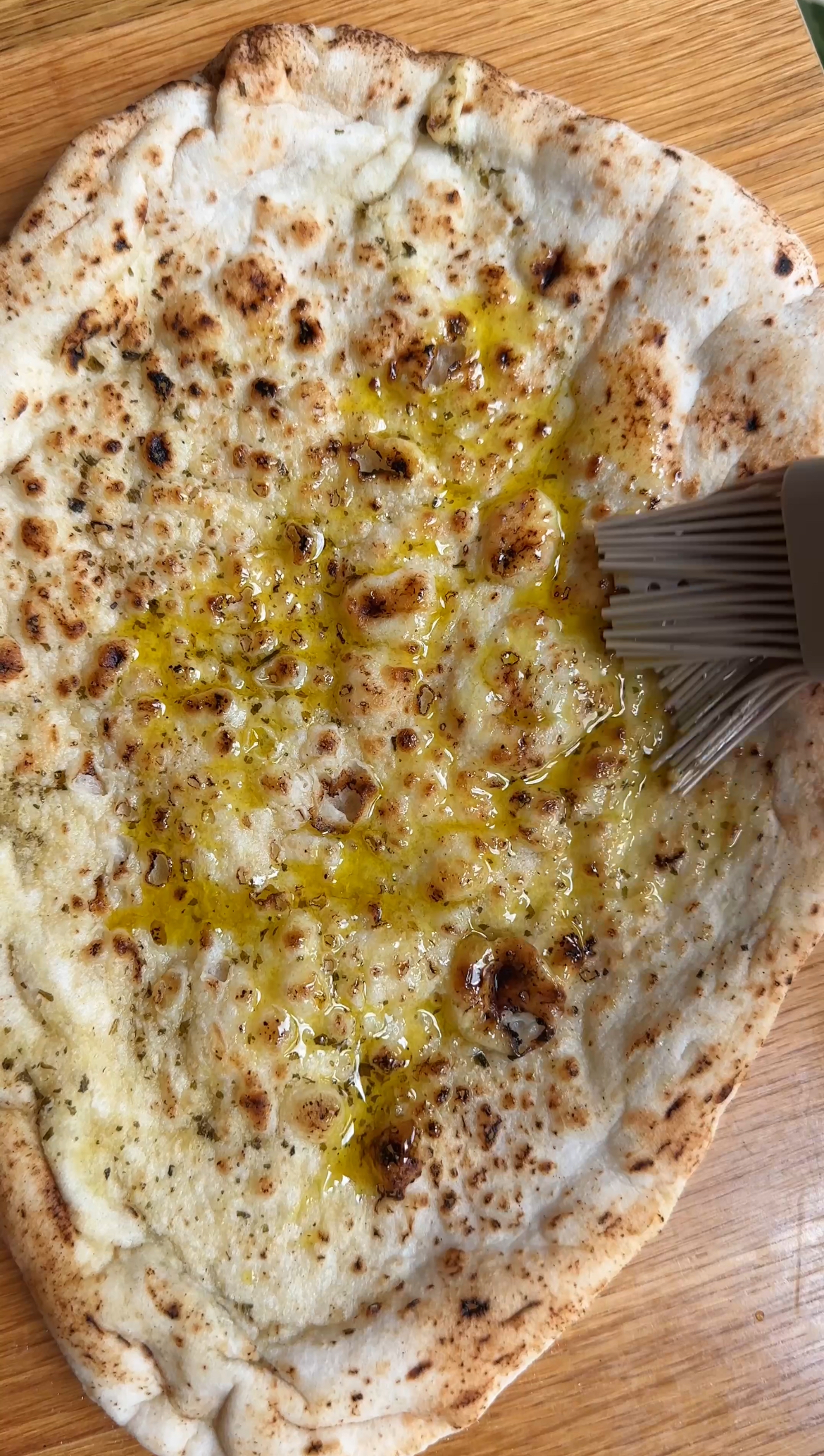 brushing the flatbread with olive oil