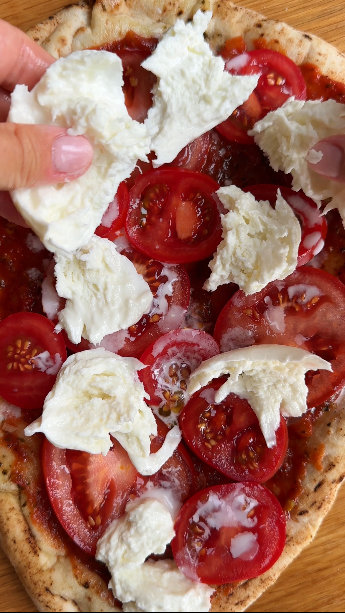 adding fresh mozzarella to flatbread pizza margherita