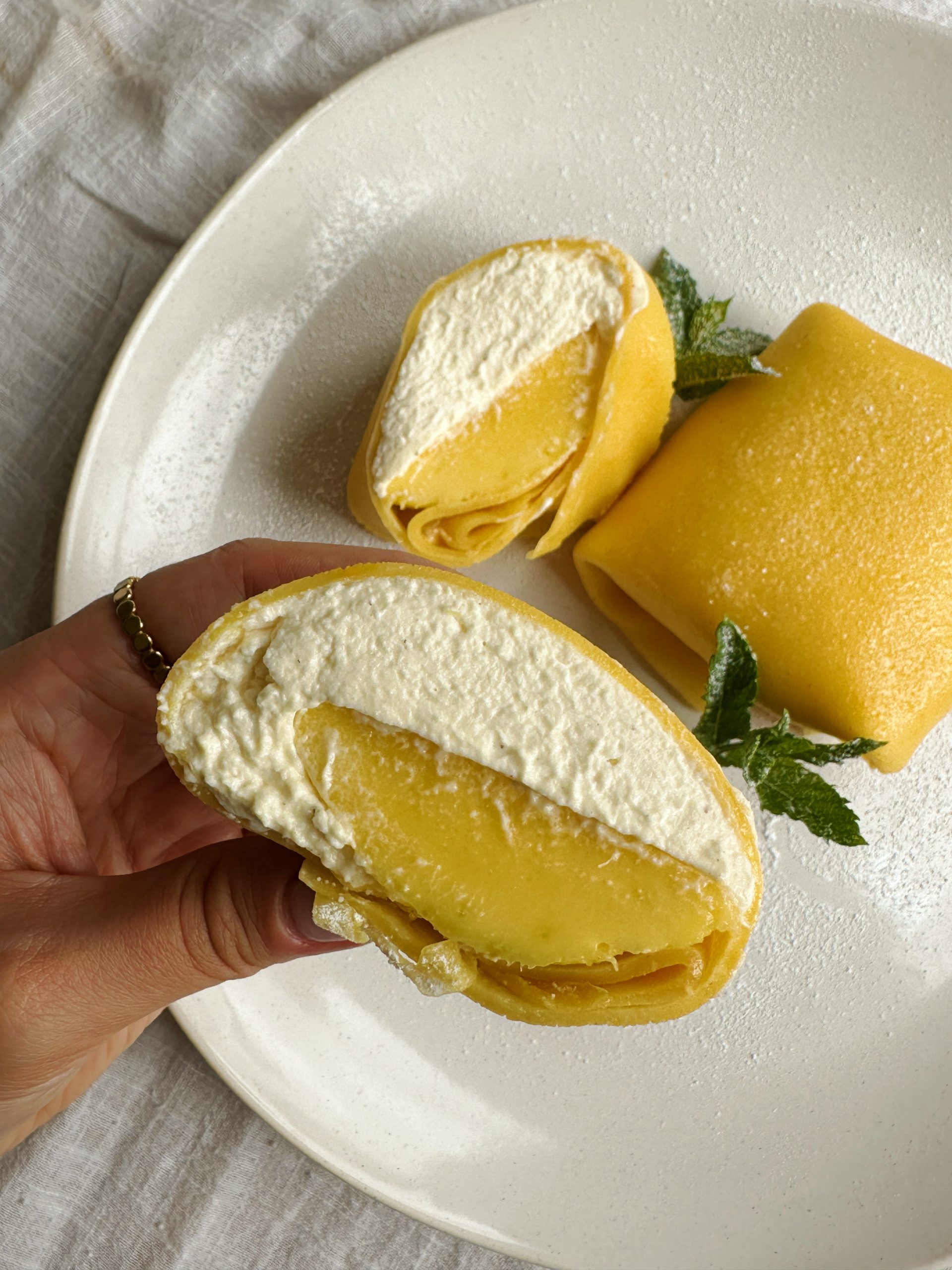 woman holding a mango pancake on a white place