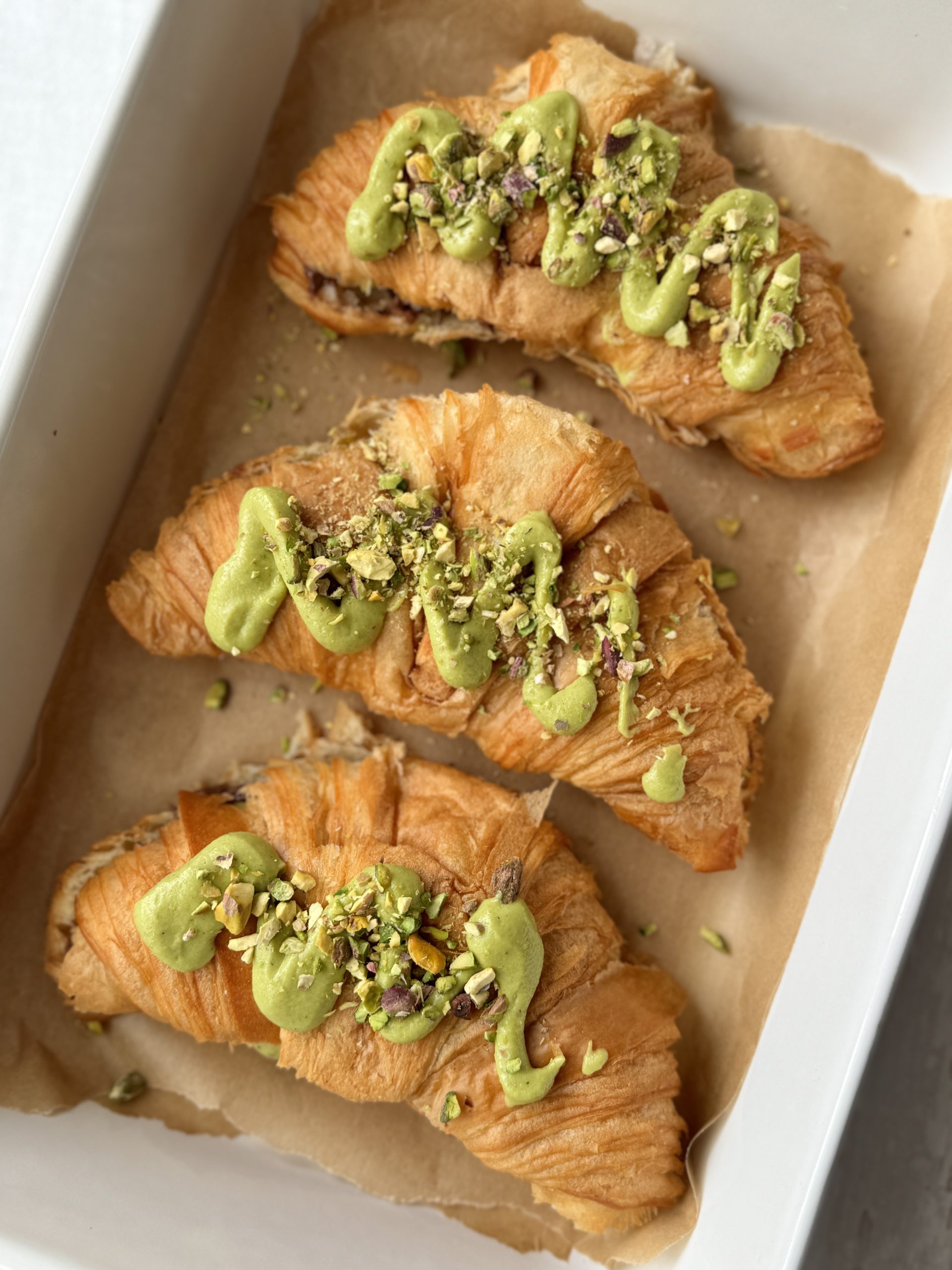 3 pistachio croissants in a baking dish