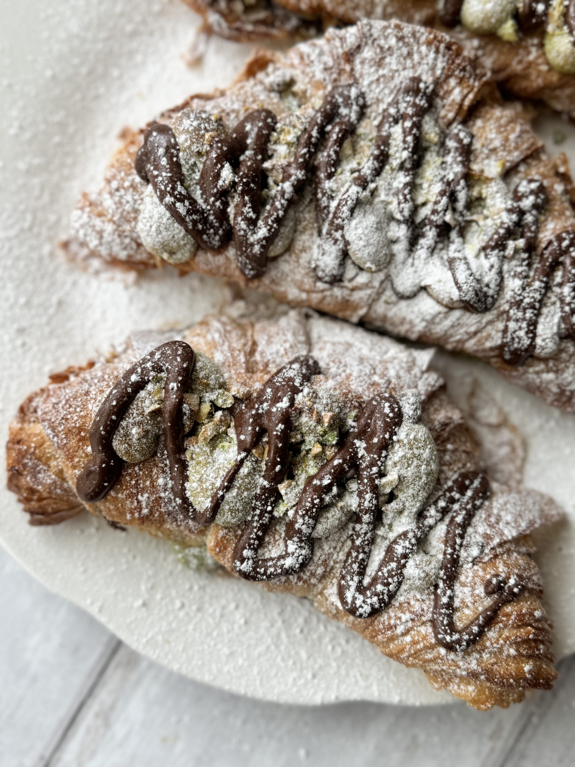 3 pistachio croissants dusted with icing sugar