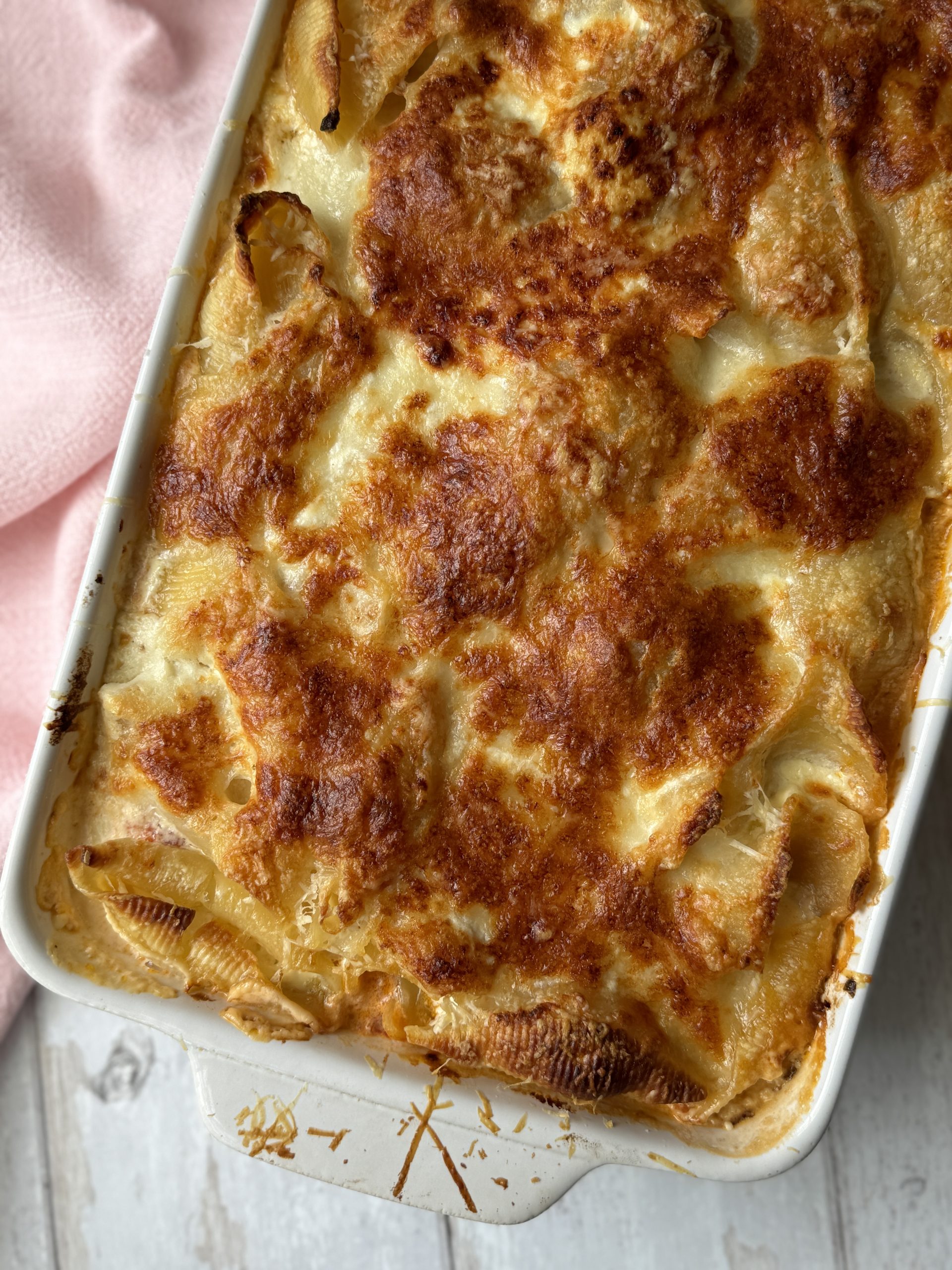 aubergine pasta with giant shells in a baking dish with a spoon