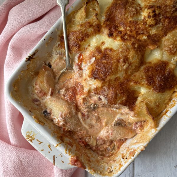 aubergine pasta with giant shells in a baking dish with a spoon