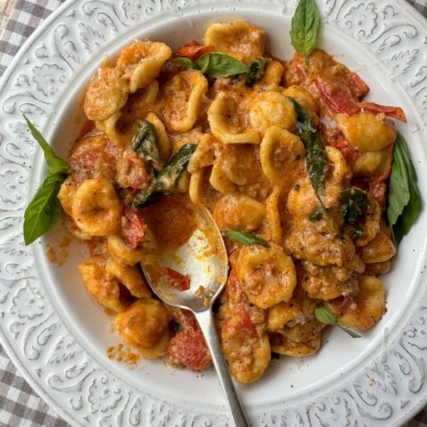 pasta con nduja in white bowl with spoon