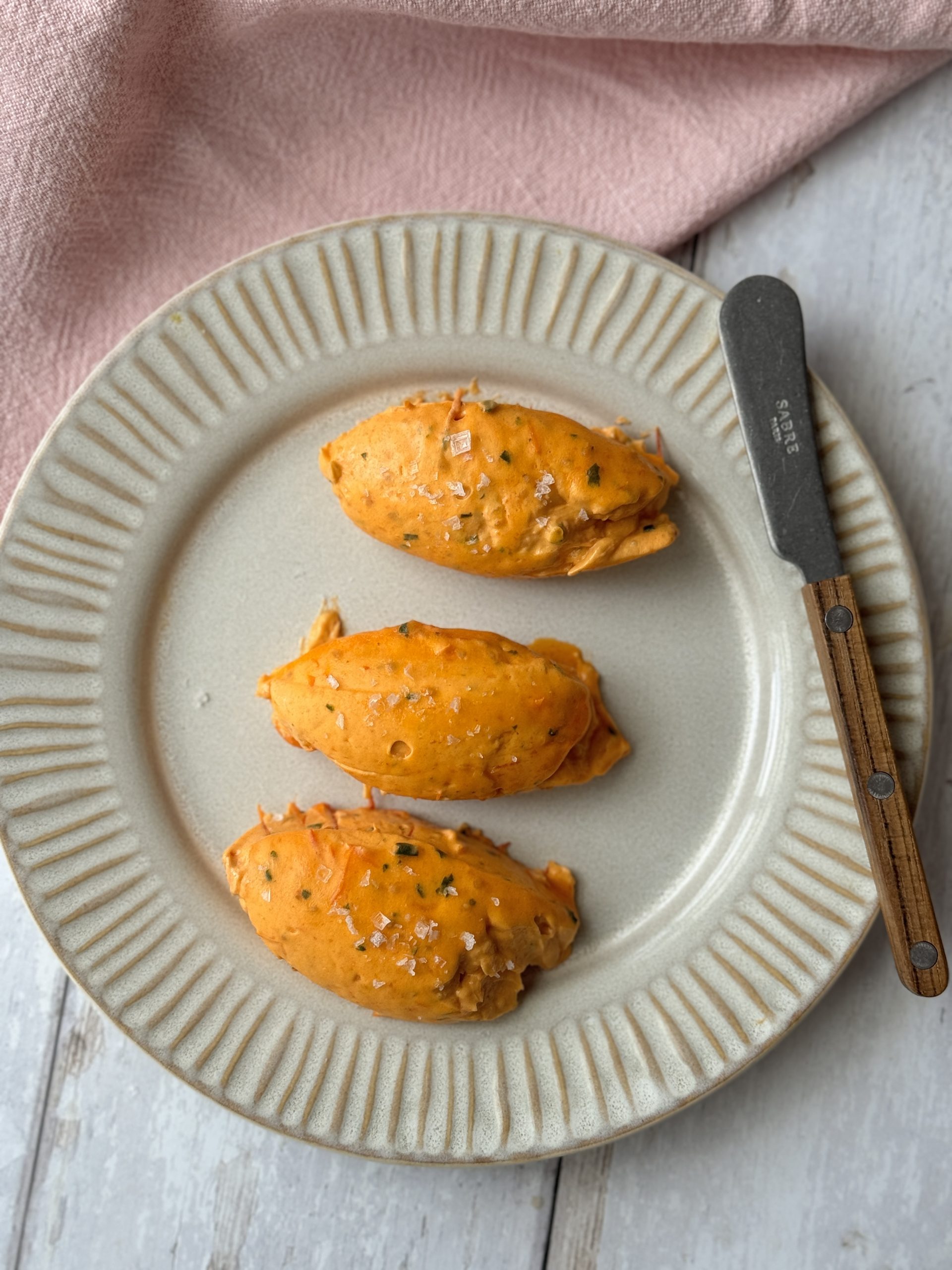 quenelles of tomato butter on a grey plate