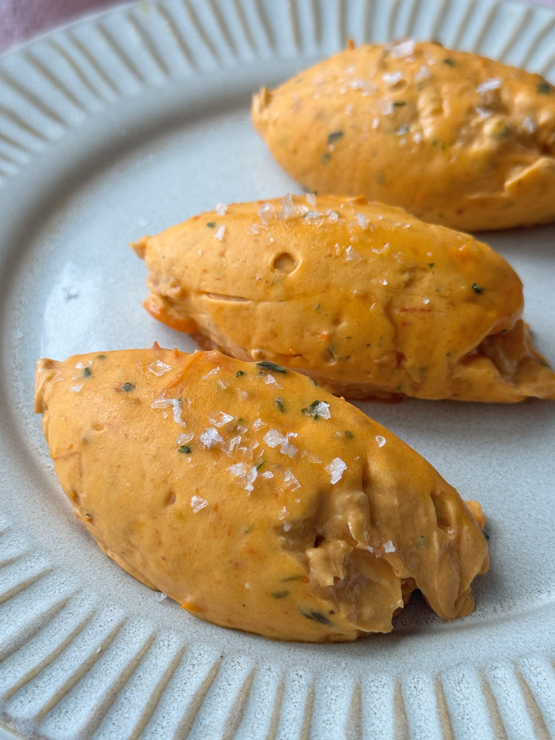 quenelles of tomato butter on a grey plate