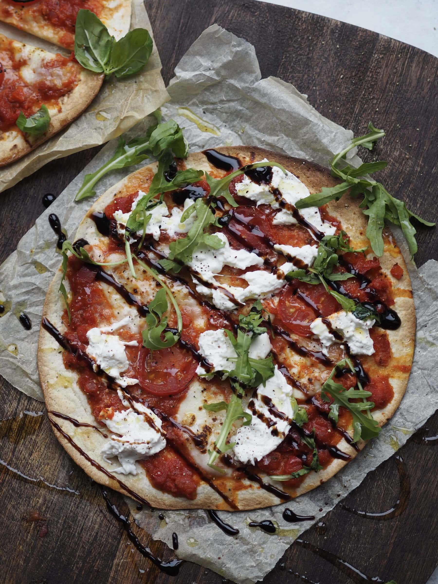 flatbread margherita pizza with rocket and balsamic glaze.