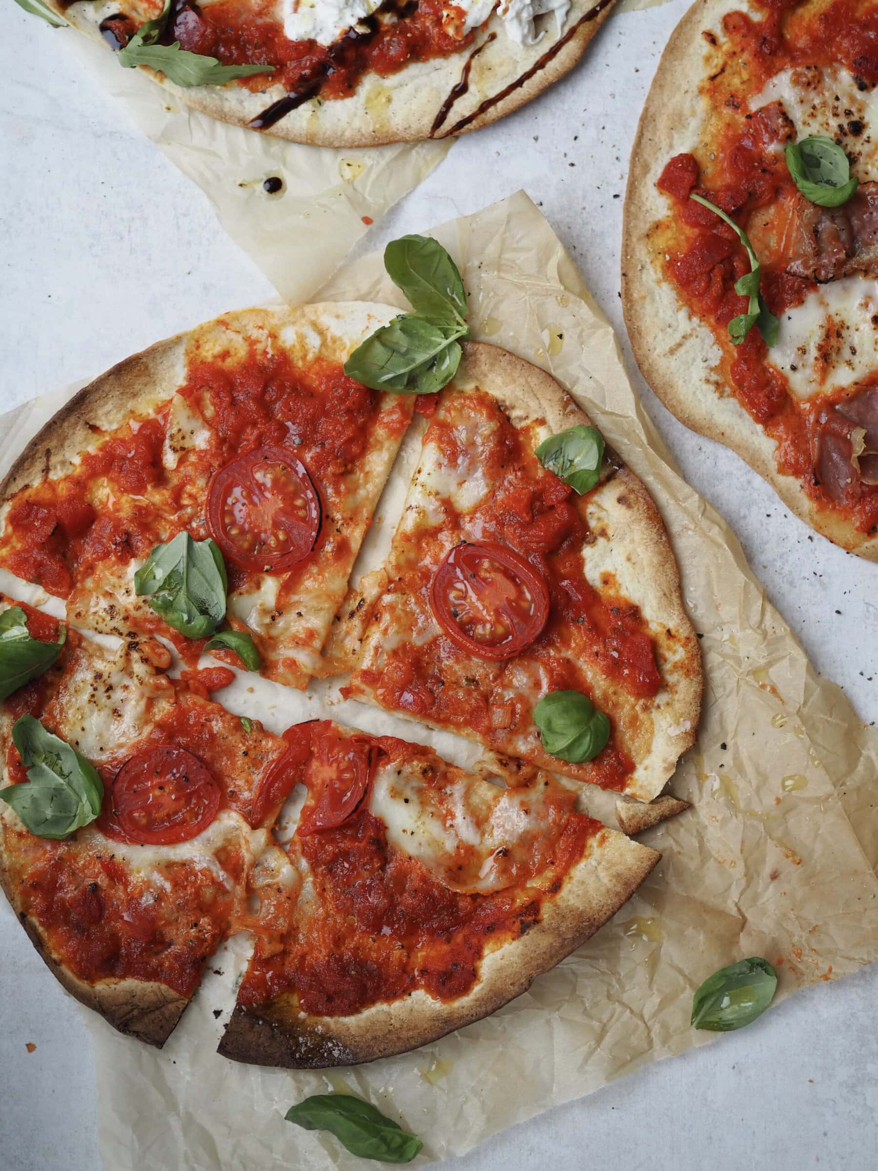 flatbread margherita pizza cut into four on greaseproof paper.