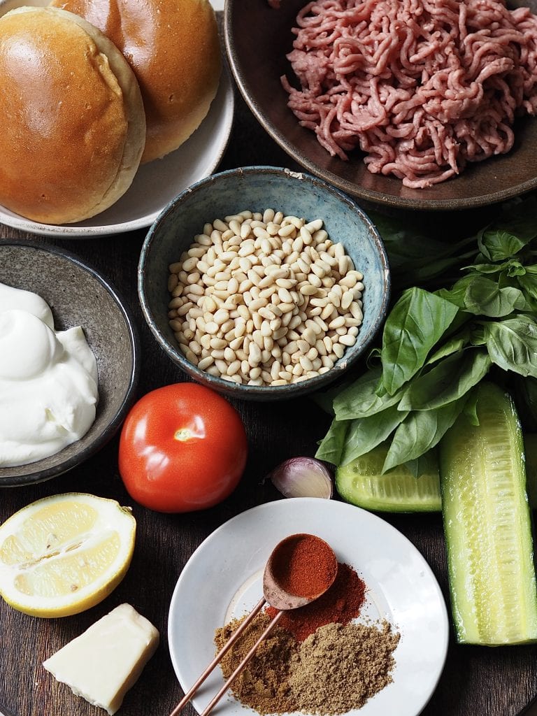 Lamb burger ingredients on a wooden countertop.