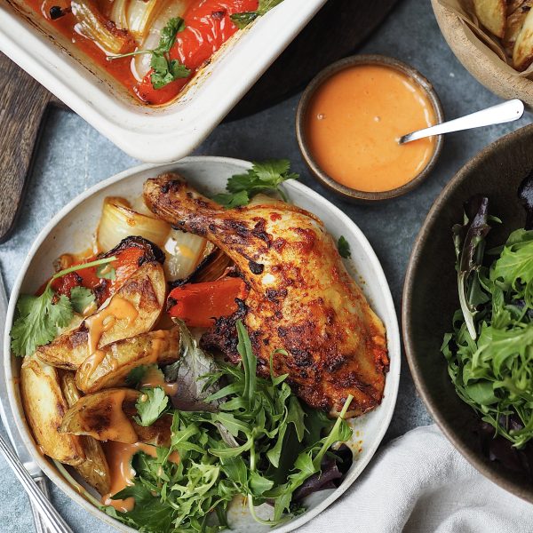 Plated peri peri chicken legs with potato wedges and salad.