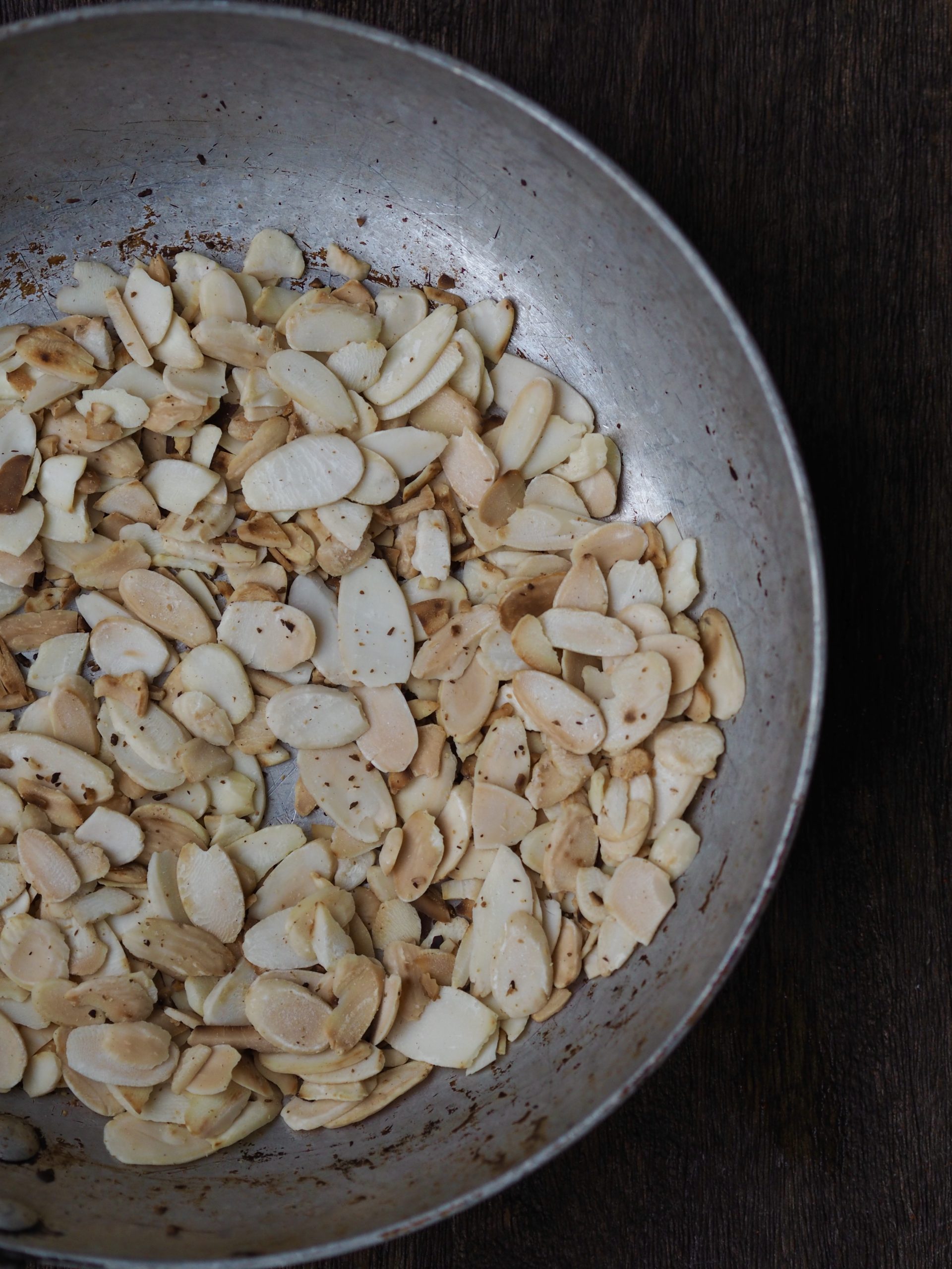 Toasted flaked almonds in a silver bowl.