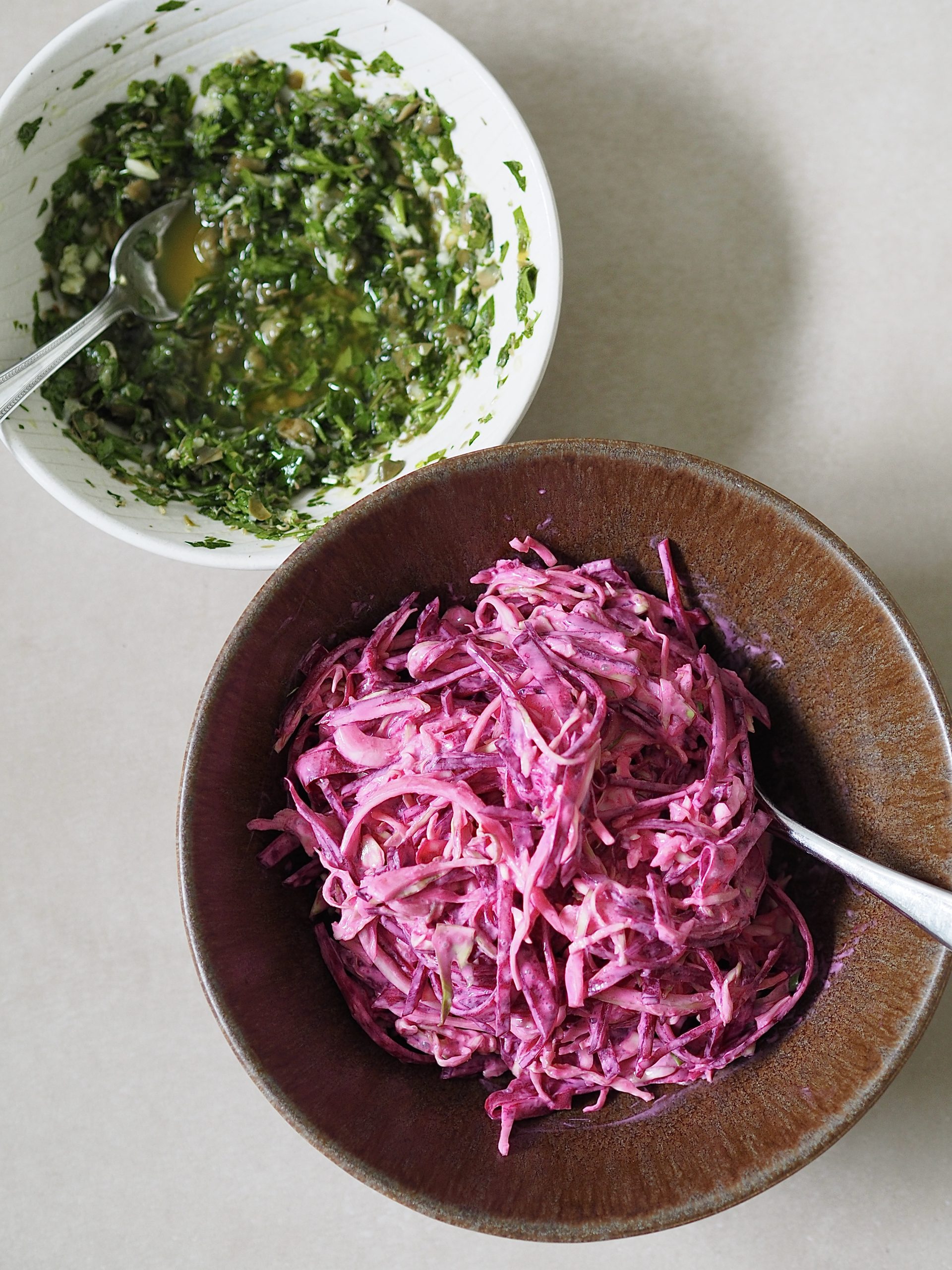 Bowls of salsa verde and yoghurt slaw on a white countertop. 