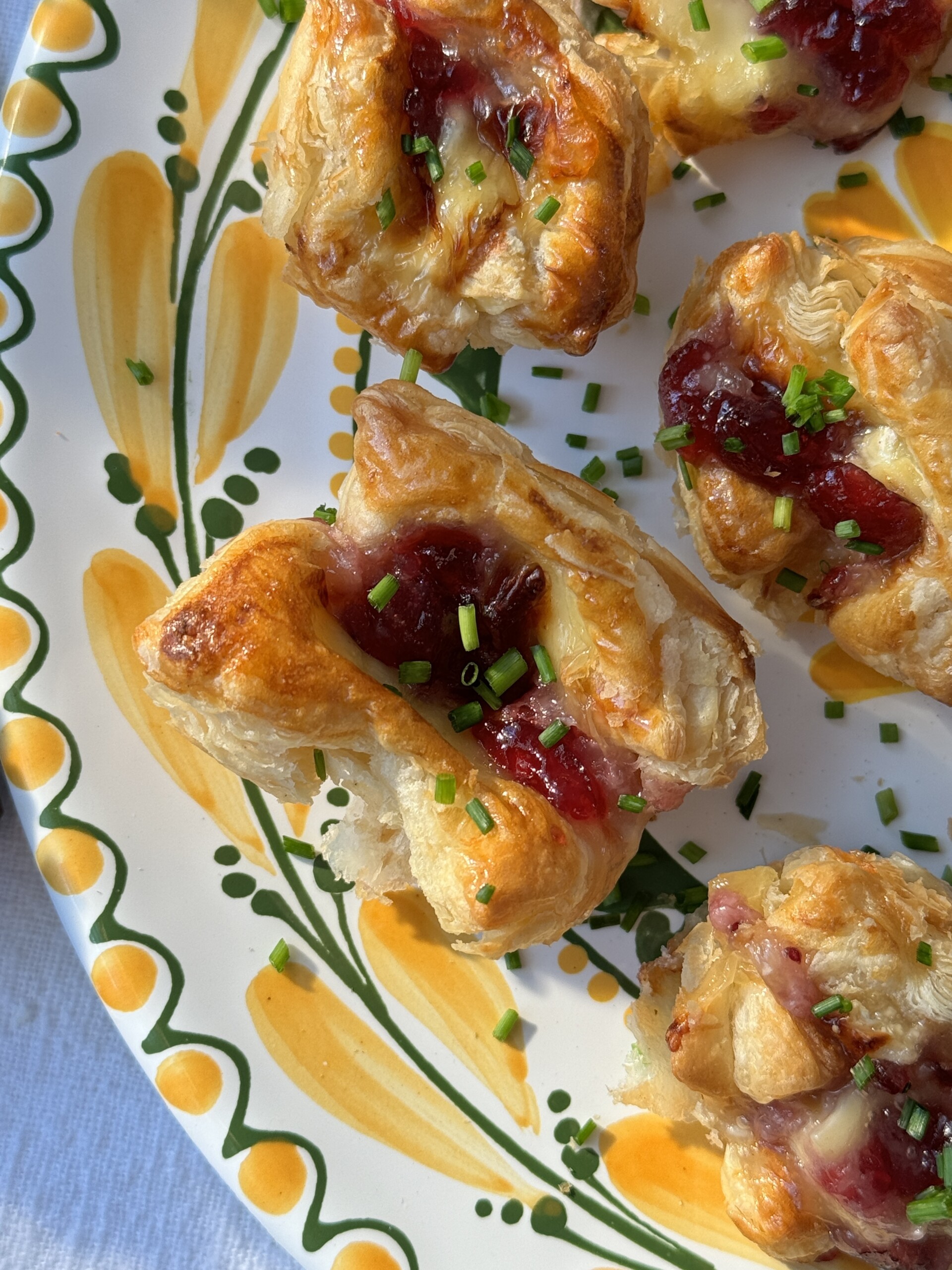 brie puff pastry bites on a plate, zoomed in.