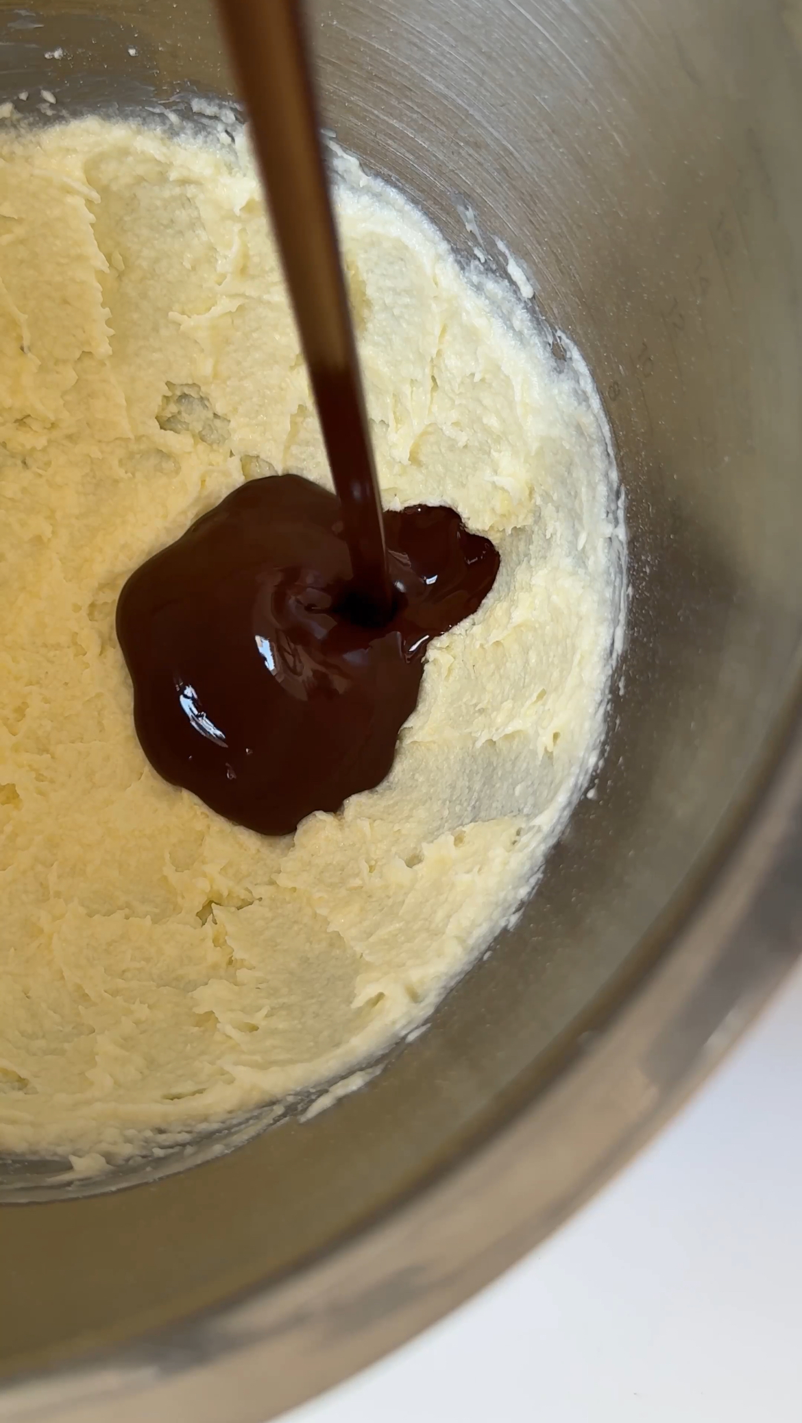 pouring melted chocolate into the frosting