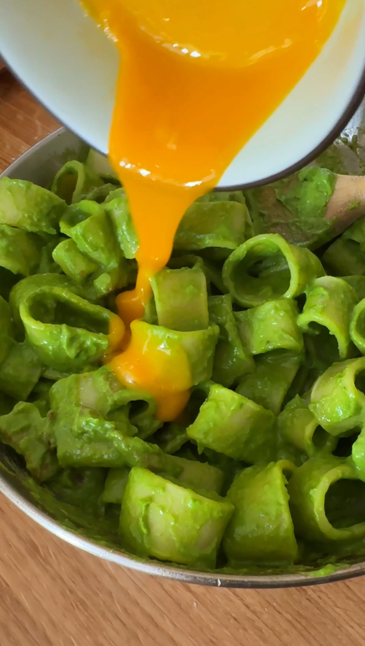 ADDING EGG YOLKS TO PASTA IN GREEN SAUCE