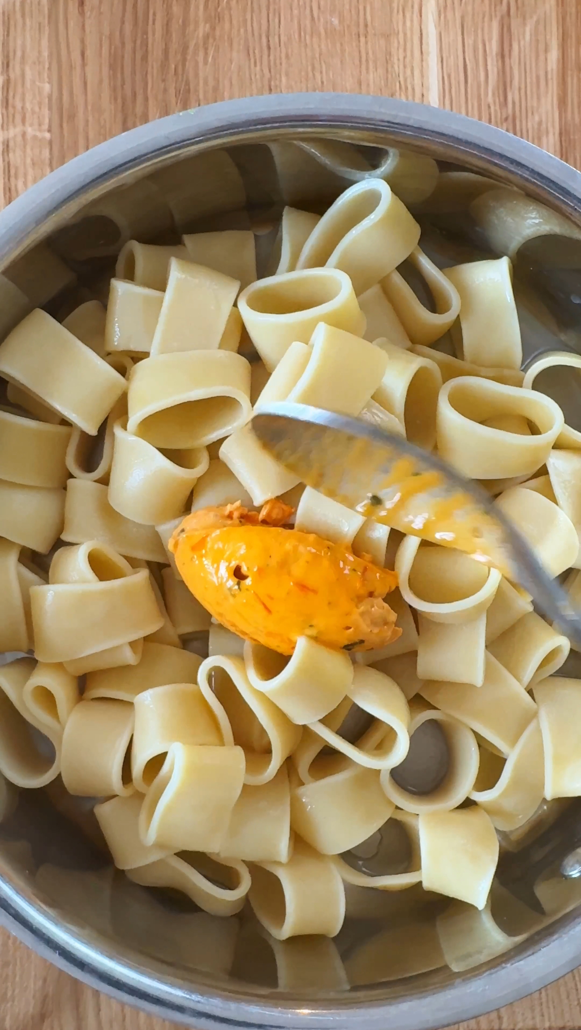 adding tomato butter to the pasta