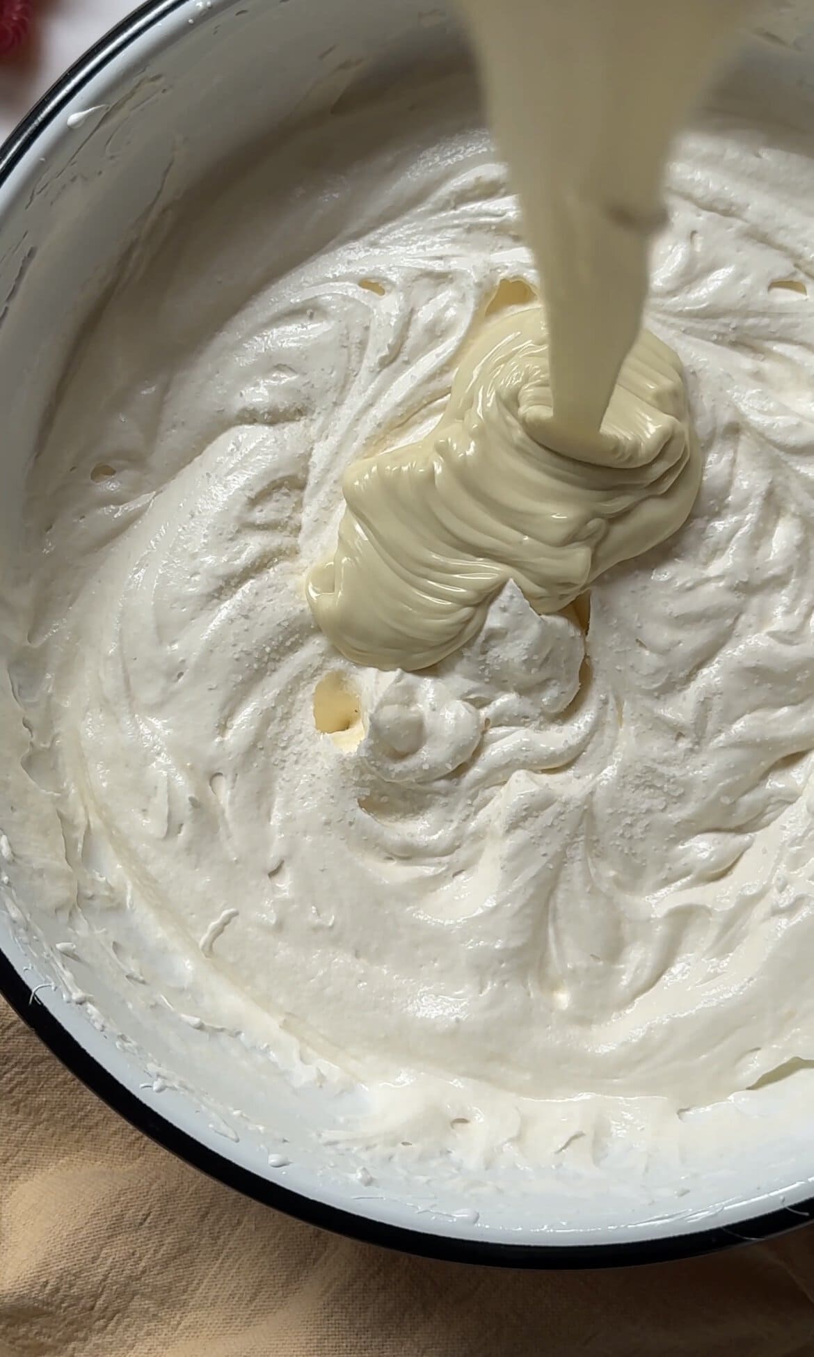 folding white chocolate into the swiss buttercream.