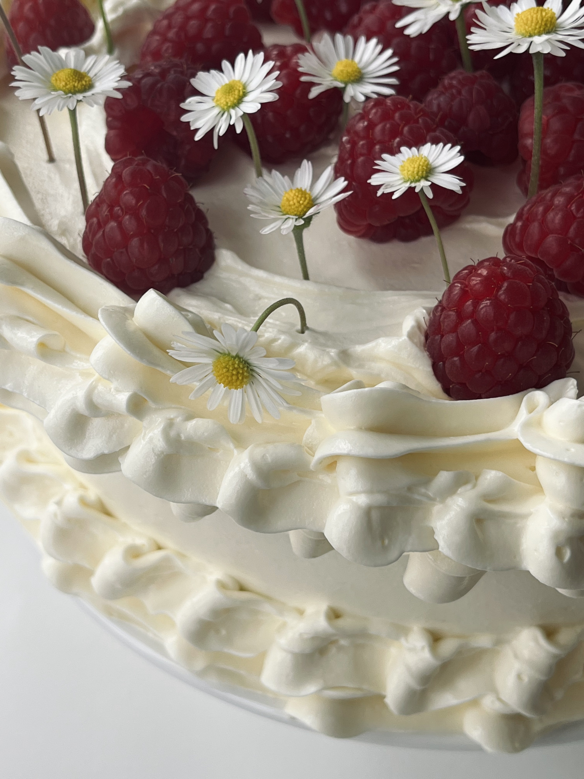 white chocolate and raspberry cake with edible flowers.