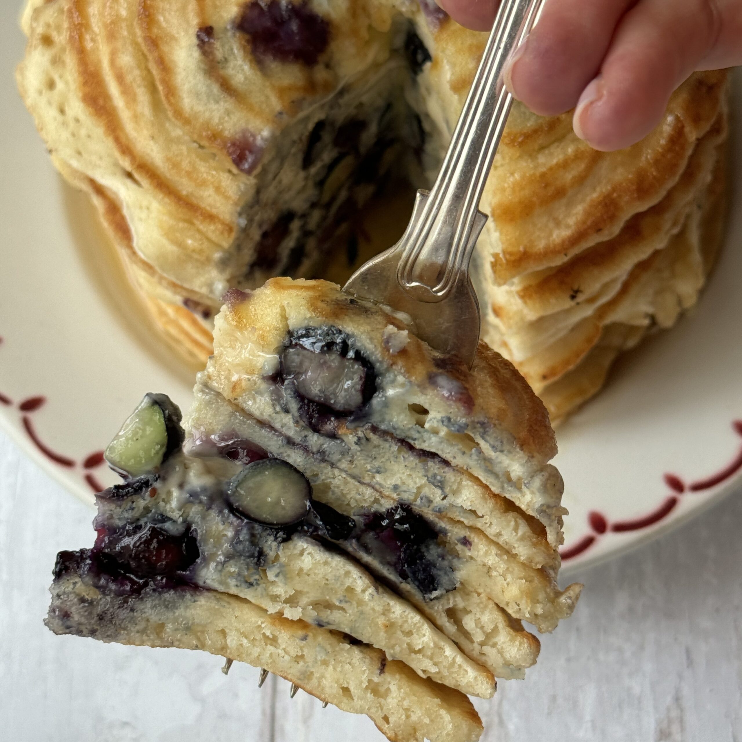 a forkful of pancakes with blueberries