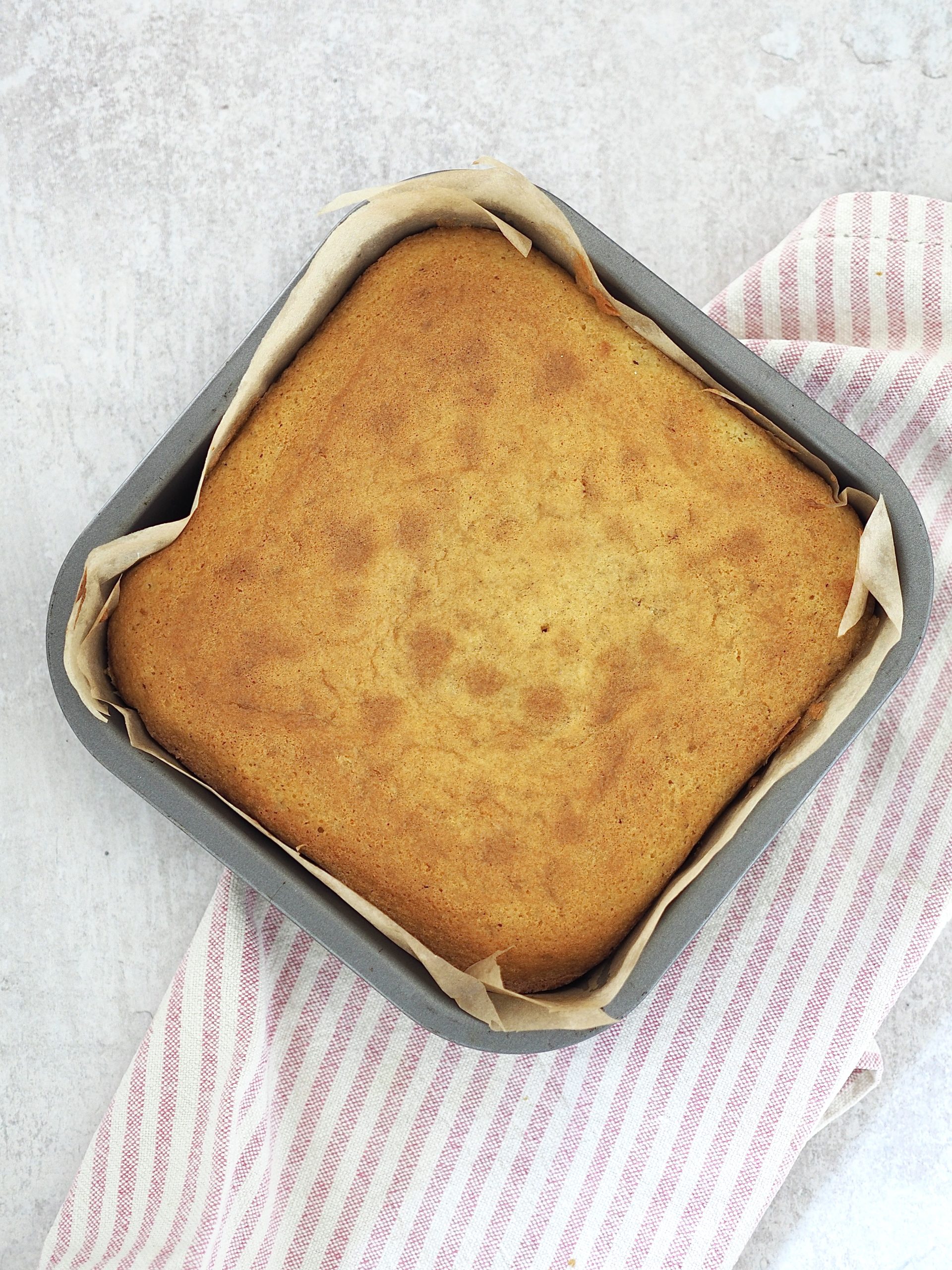 A baked sponge in a lined tin.