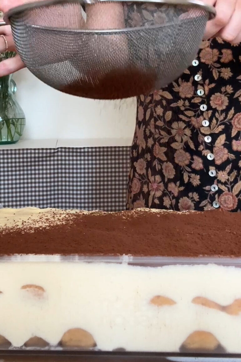 powdering cocoa powder on baileys tiramisu