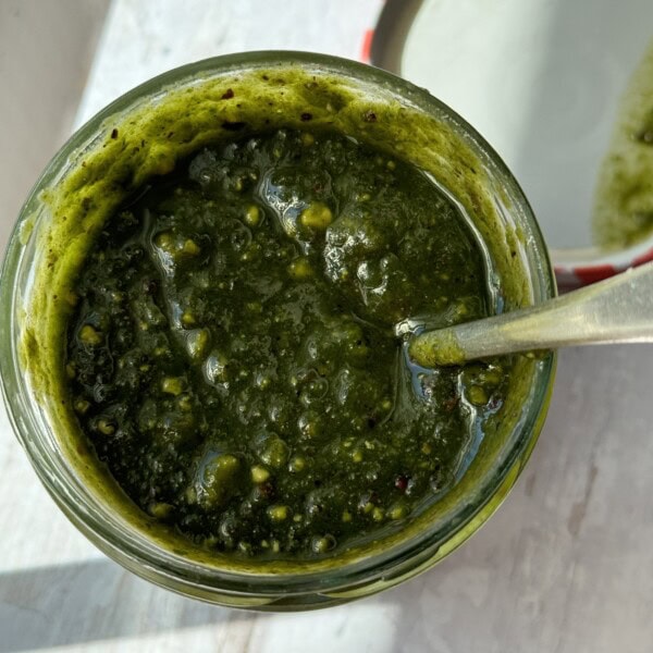 spooning out pistachio pesto from jar