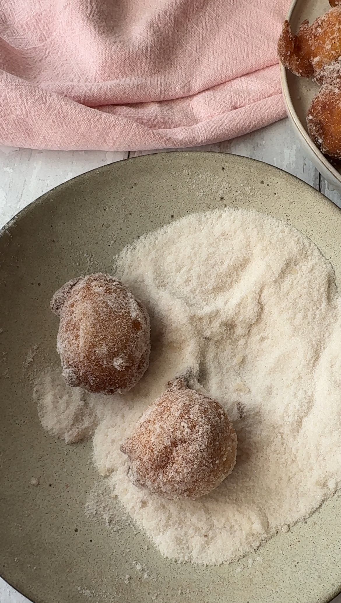 rolling doughnuts in sugar