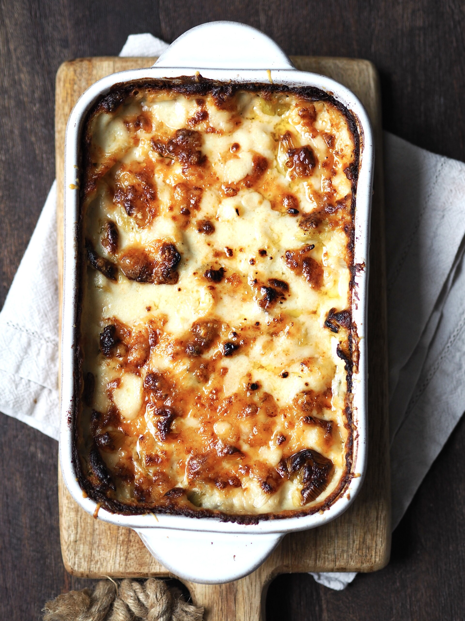 Overhead picture of a white baking dish of cheesy baked leeks.