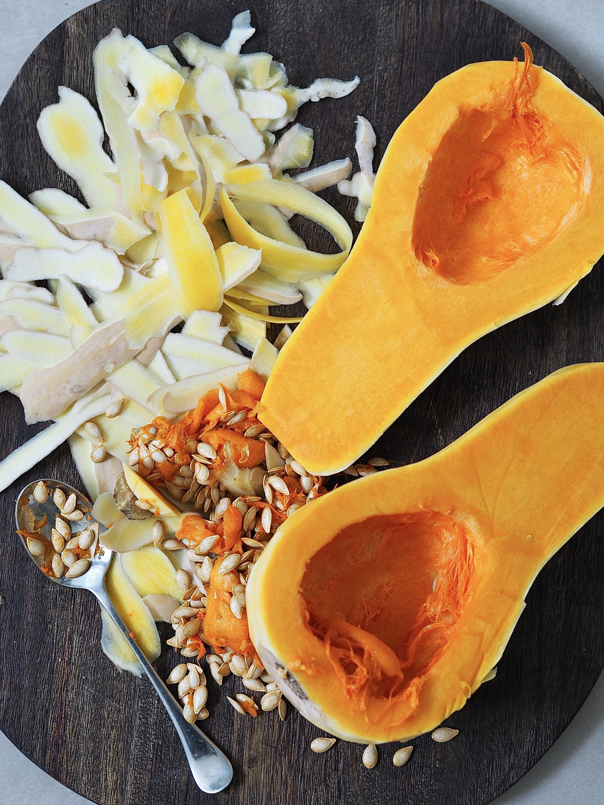 Peeled butternut squash on a wooden chopping board.