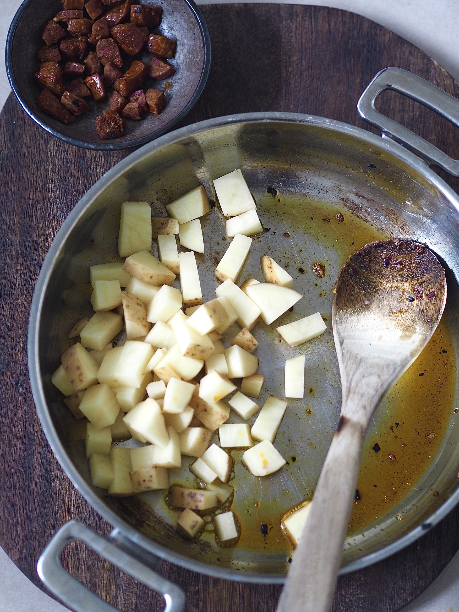 Adding the potato cubes to the pan with the chorizo oil