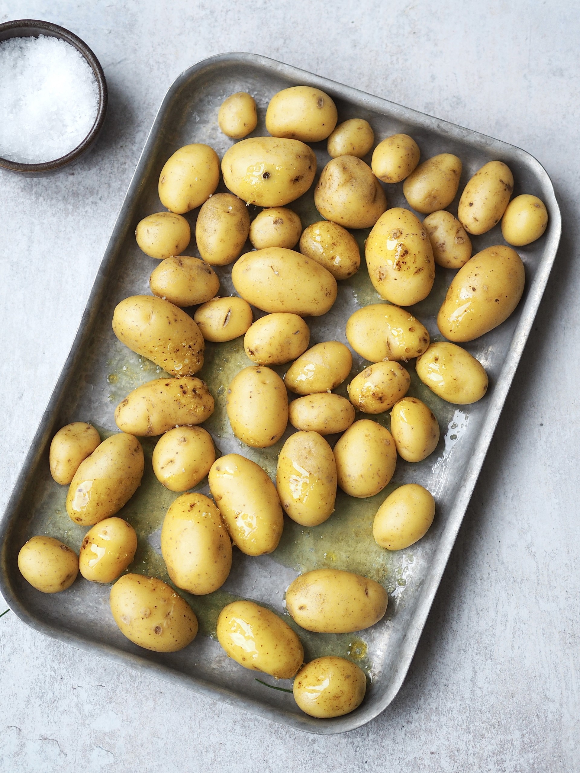 Preheat the oven to 200°C Fan. Toss seasoned potatoes with olive oil on a baking tray and roast for 40 minutes, turning halfway, until golden and tender.