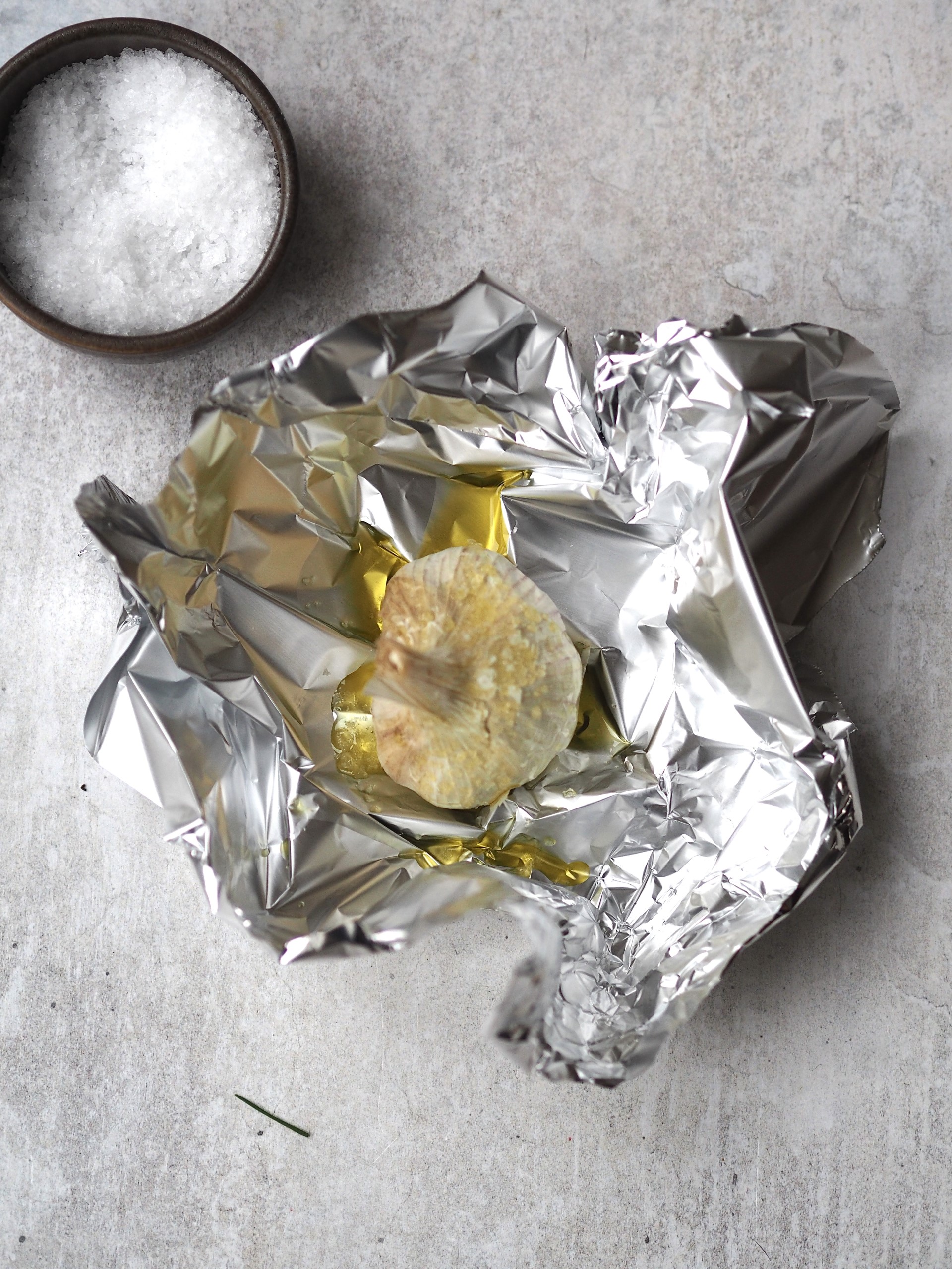 Preparing garlic to bake in oven.