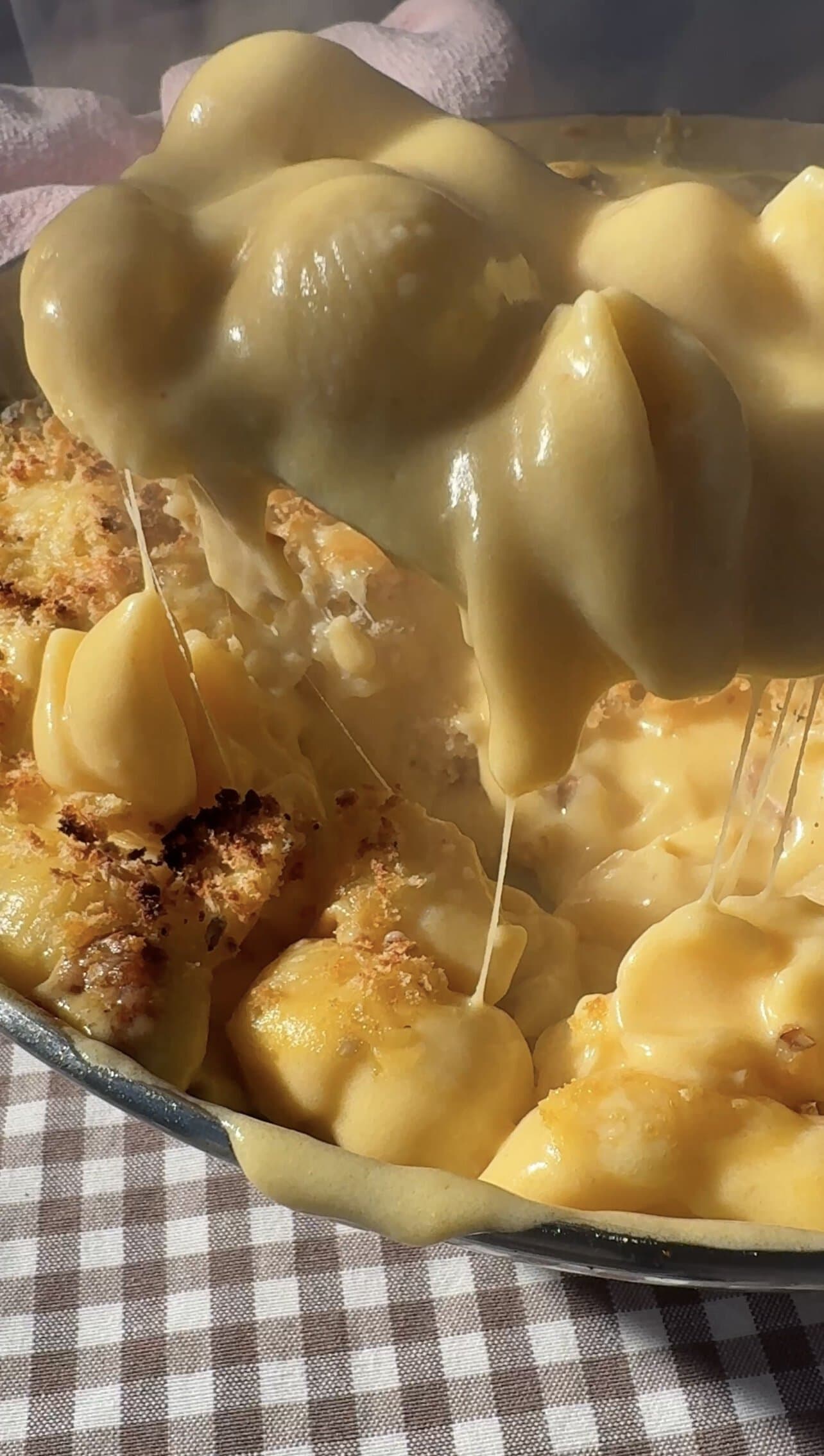 gouda Mac and cheese scooping from a pan.