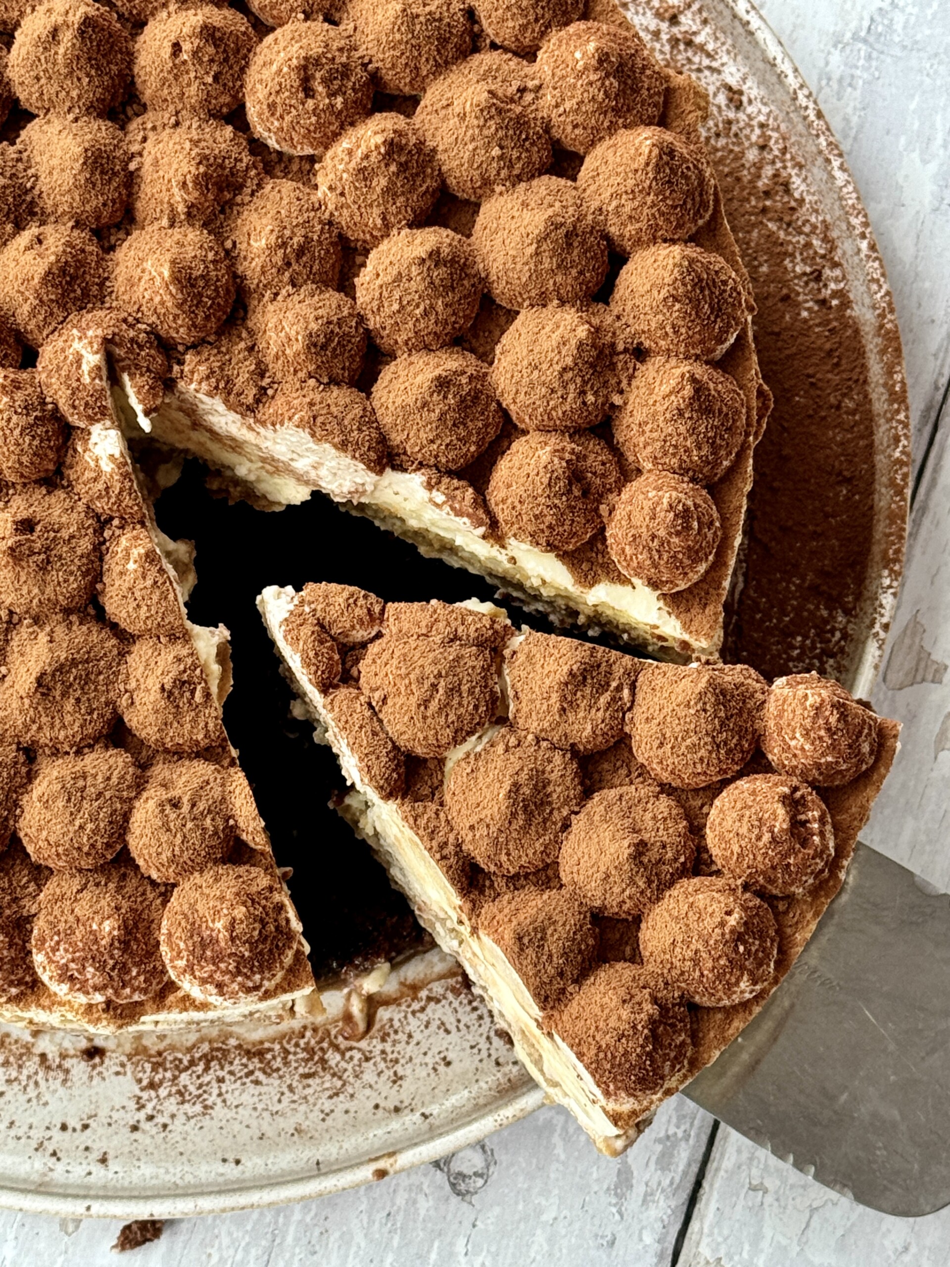 overhead shot of slice removed from tiramisu cheesecake