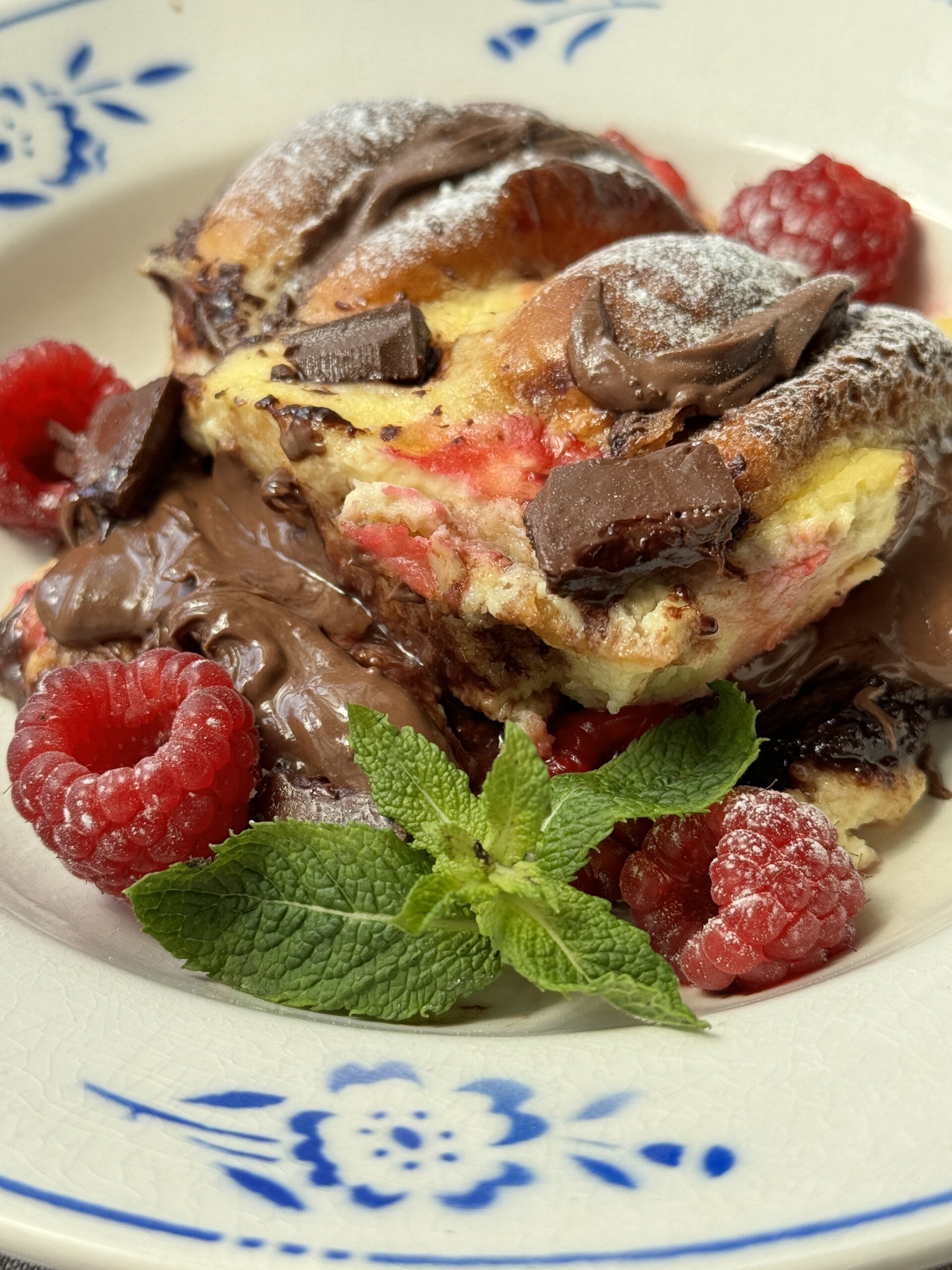 a portion of bread and brioche pudding on plate with blue flowers - close up