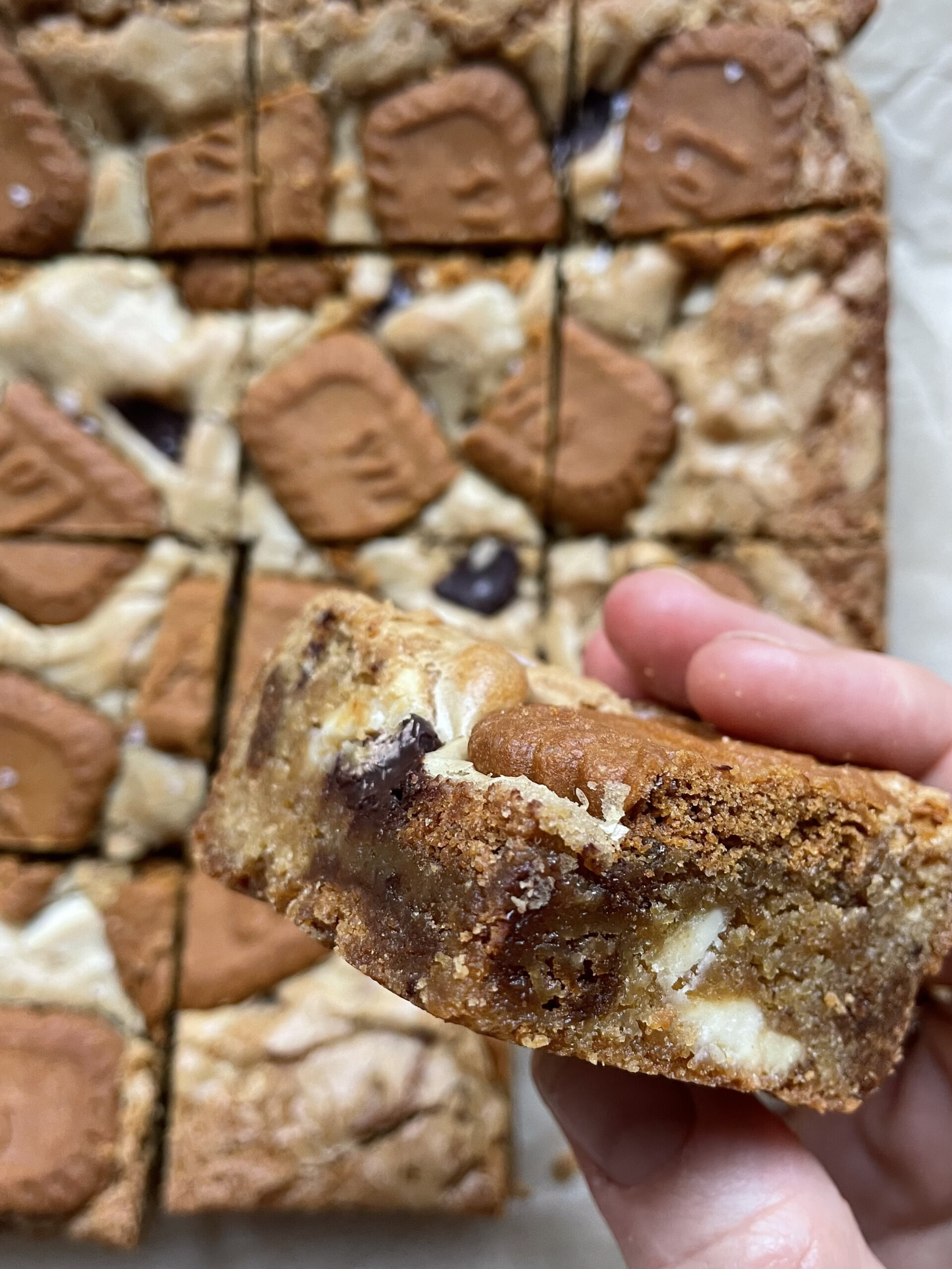 woman holding biscoff blondie over the tray