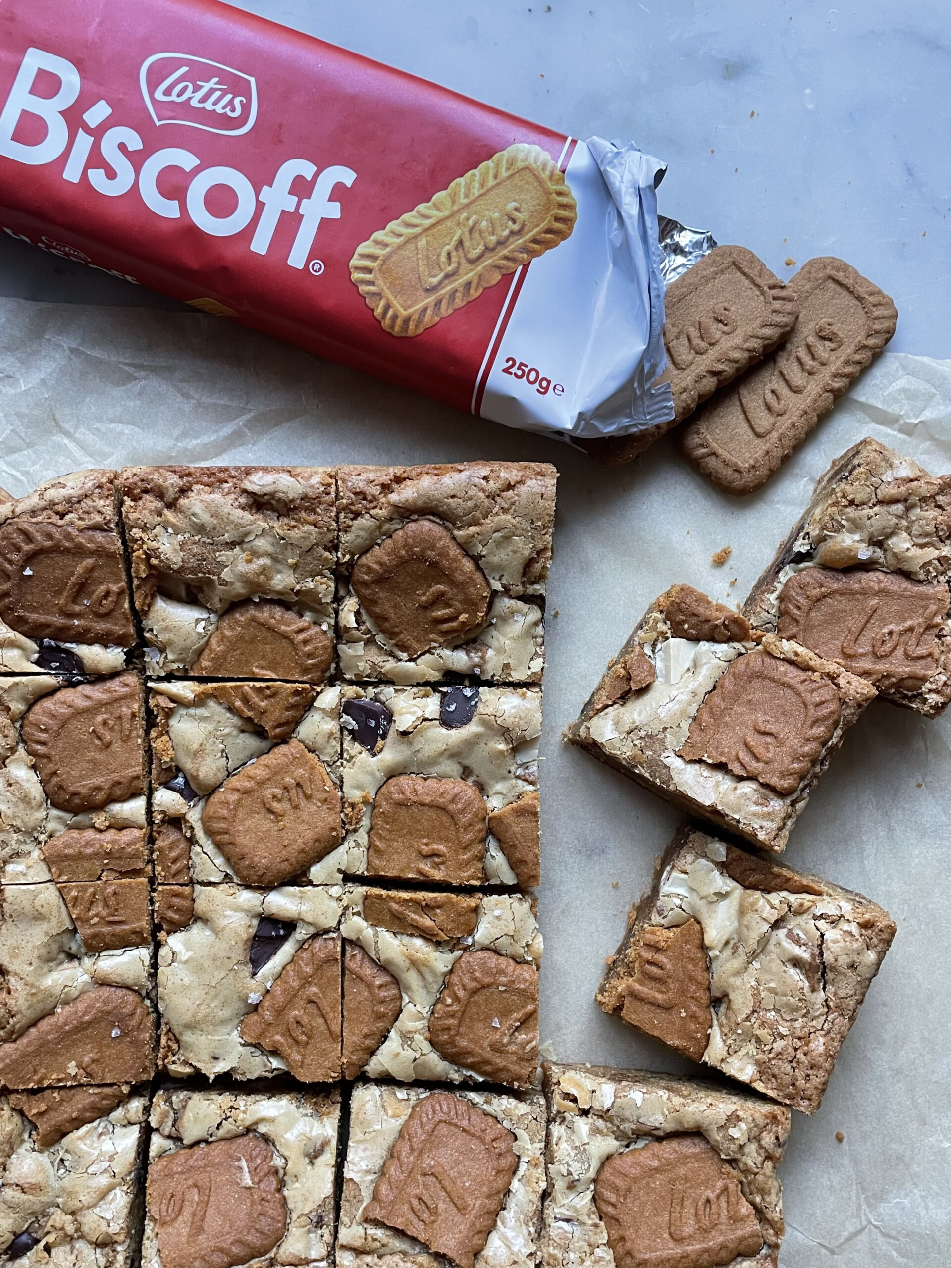 biscoff blondies on parchment paper with lotus biscuits