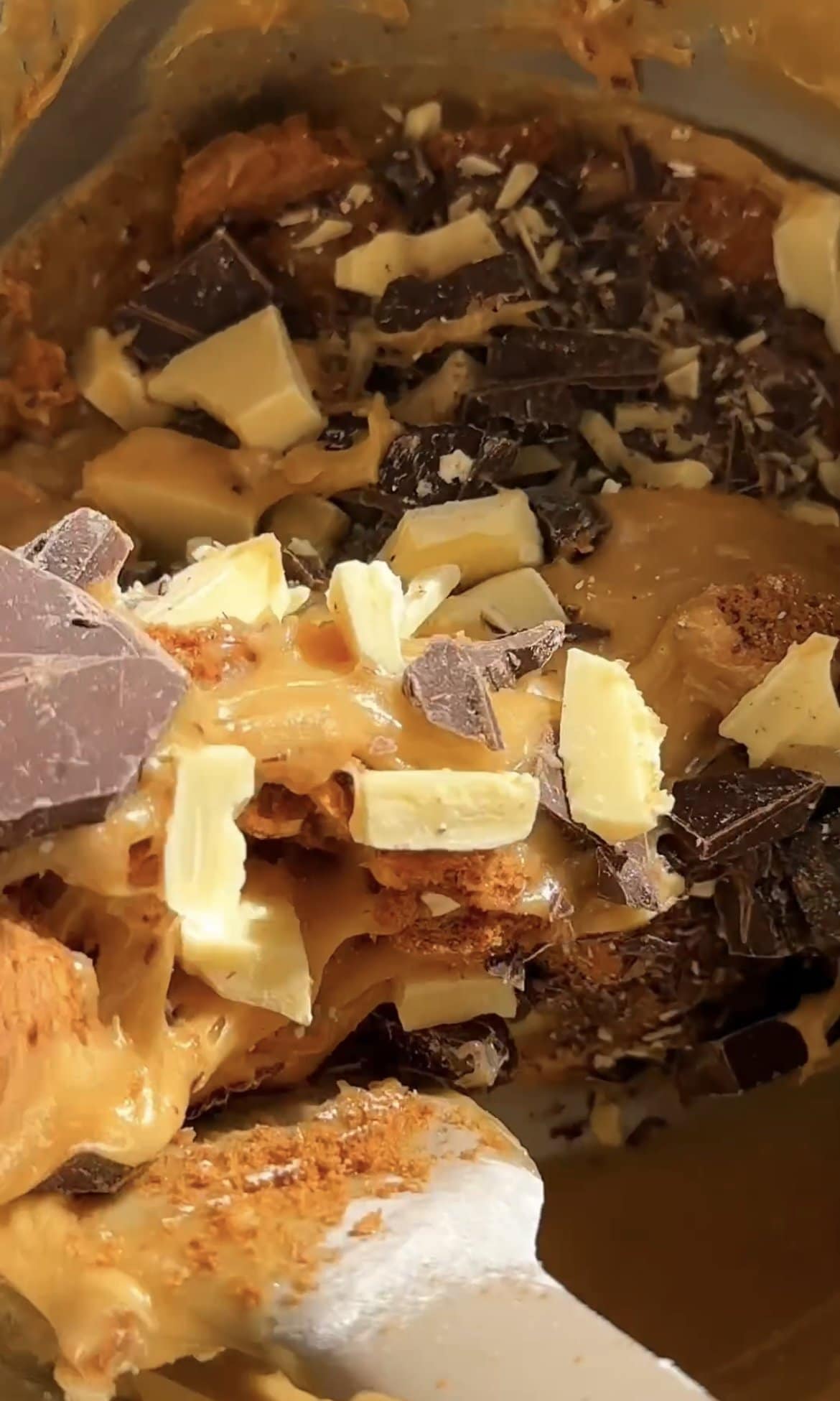 stirring chocolate chunks into blondie batter.