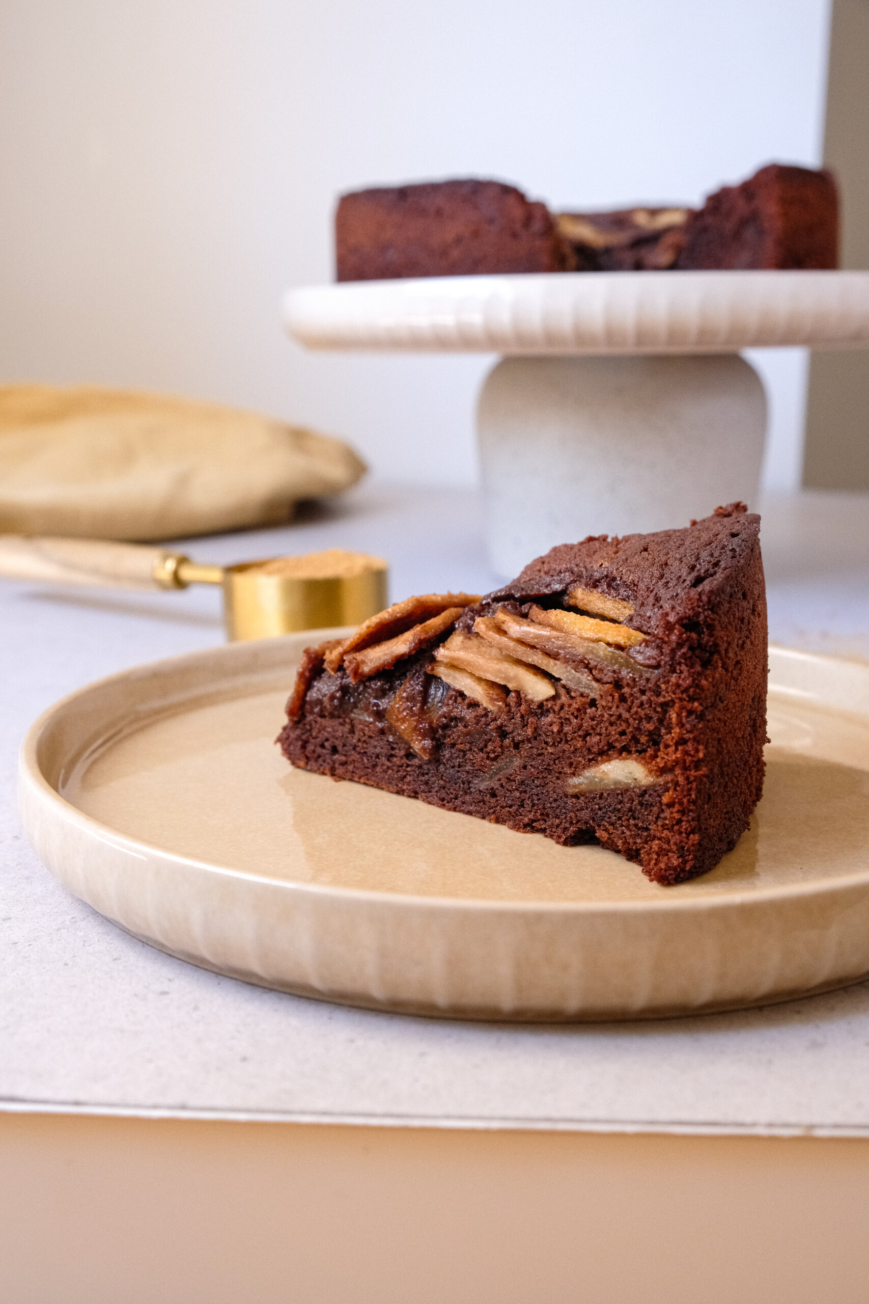 chocolate and pear cake slice on beige plate